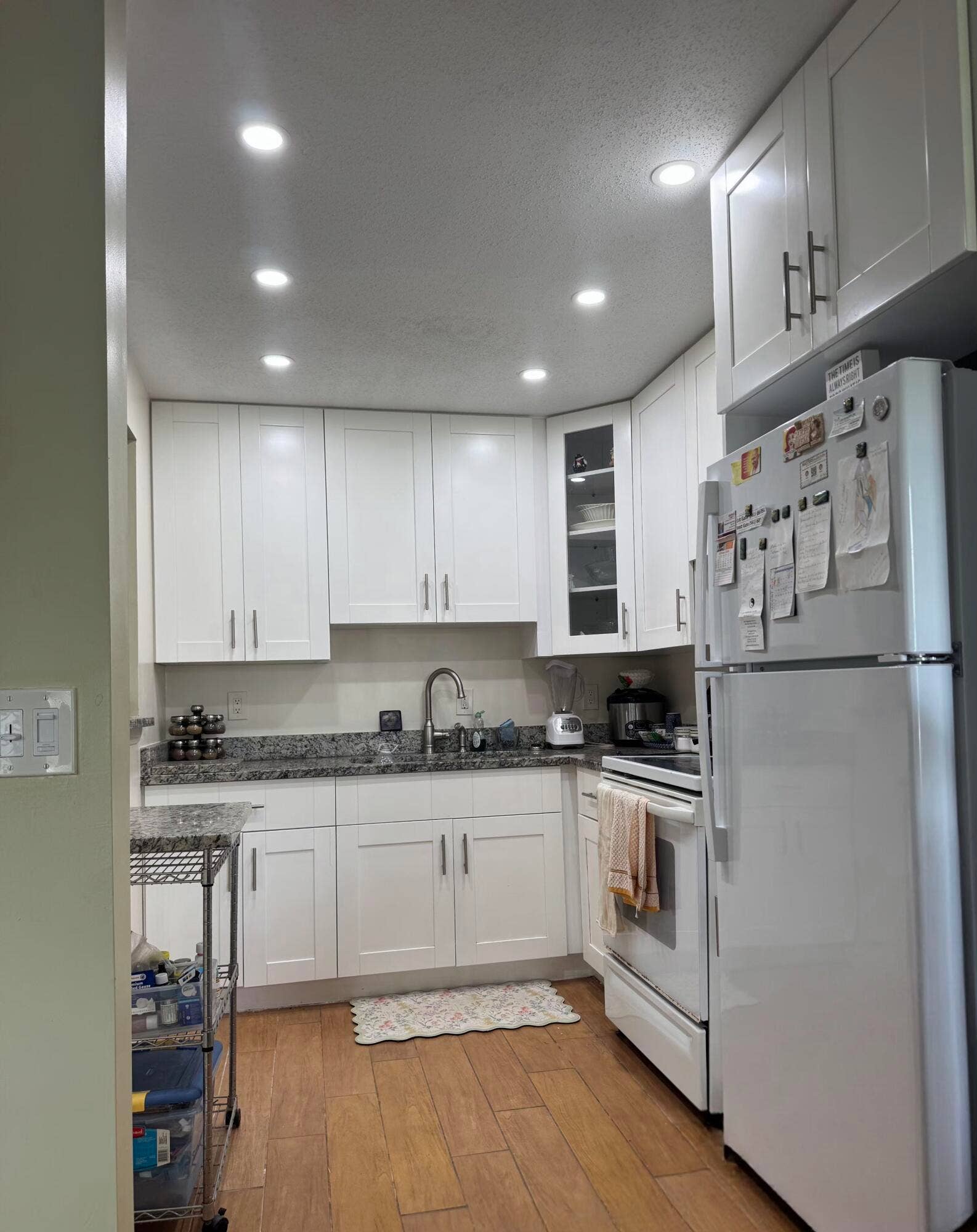 178 Coventry H, West Palm Beach, West Palm Beach, FL 33417 Wood-finish flooring, white cabinetry with dark hardware, stone countertops, recessed lighting, and a corner glass-front cabinet
