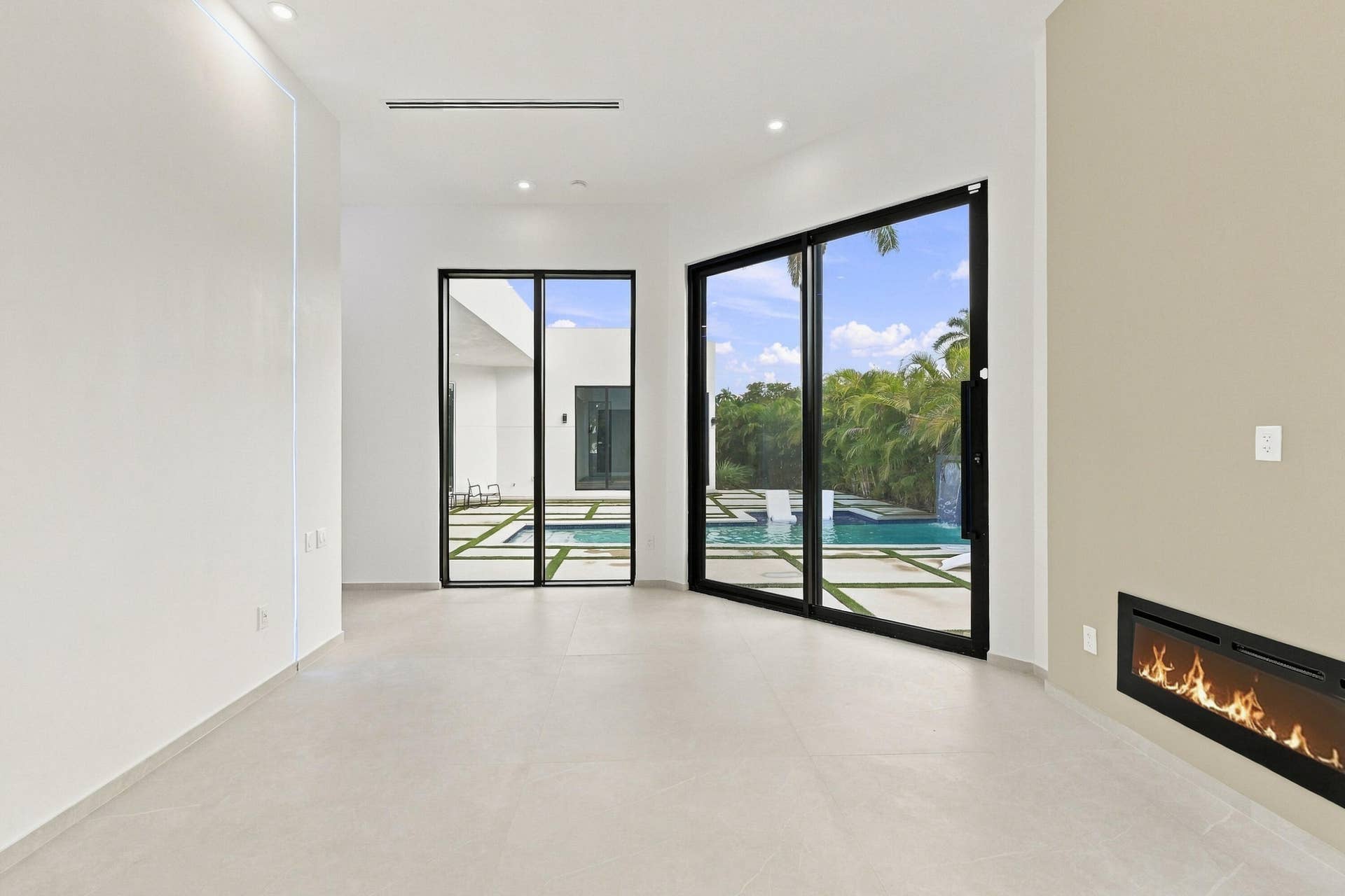 Recessed lighting, tile flooring, two sets of glass sliding doors, built-in fireplace, and a private pool