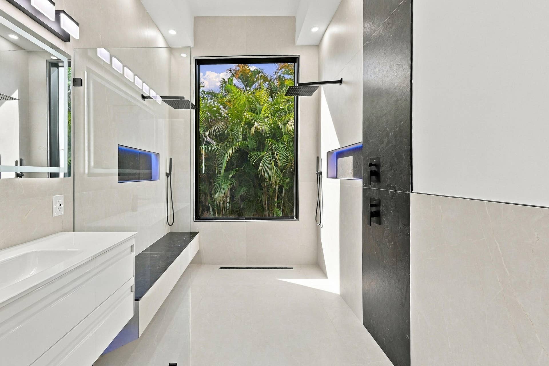 Modern primary bathroom featuring a floating vanity with rectangular vessel sink, quartz countertop, and matte black wall-mounted faucet