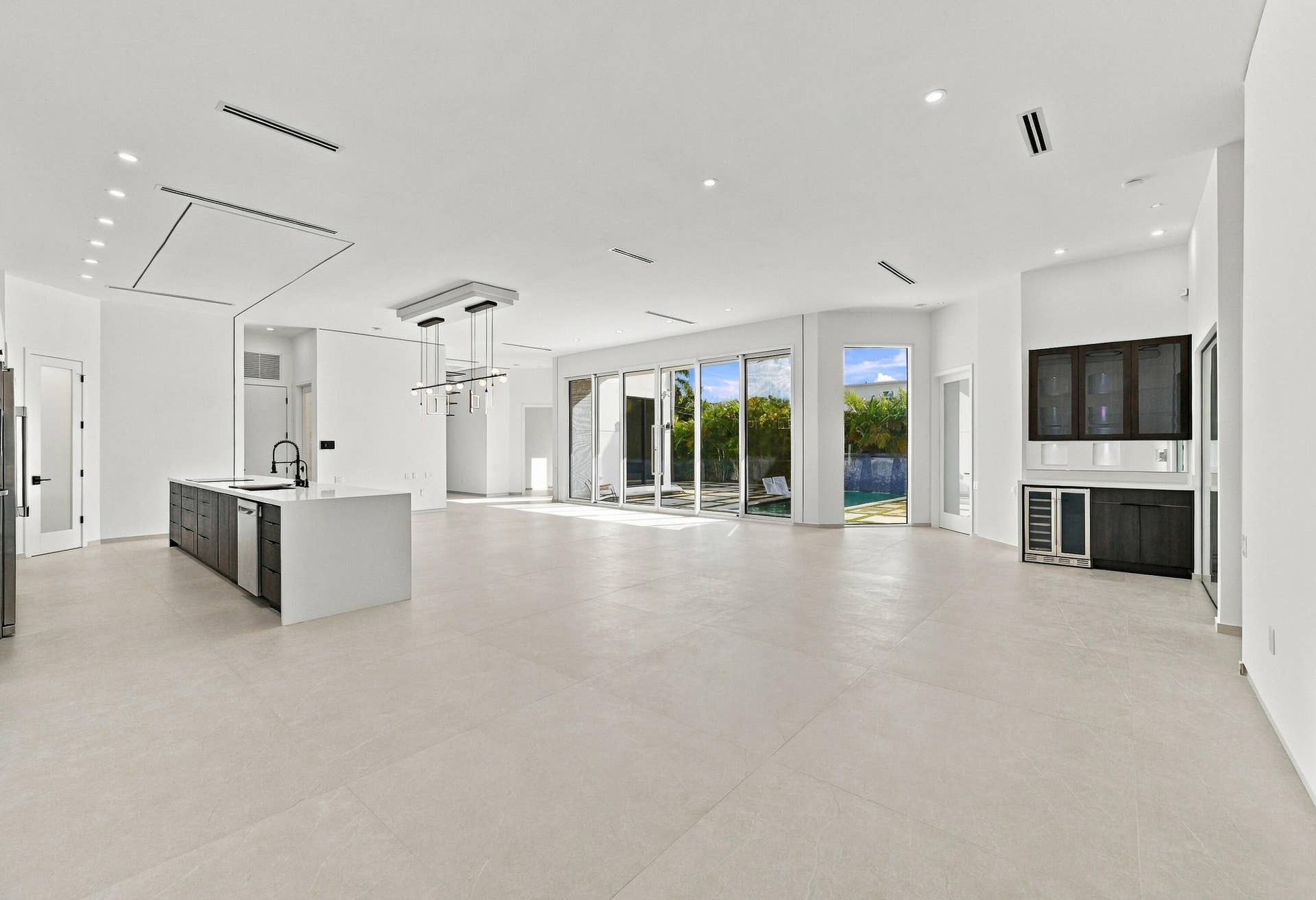 Expansive open-concept living space featuring light-toned polished concrete flooring throughout