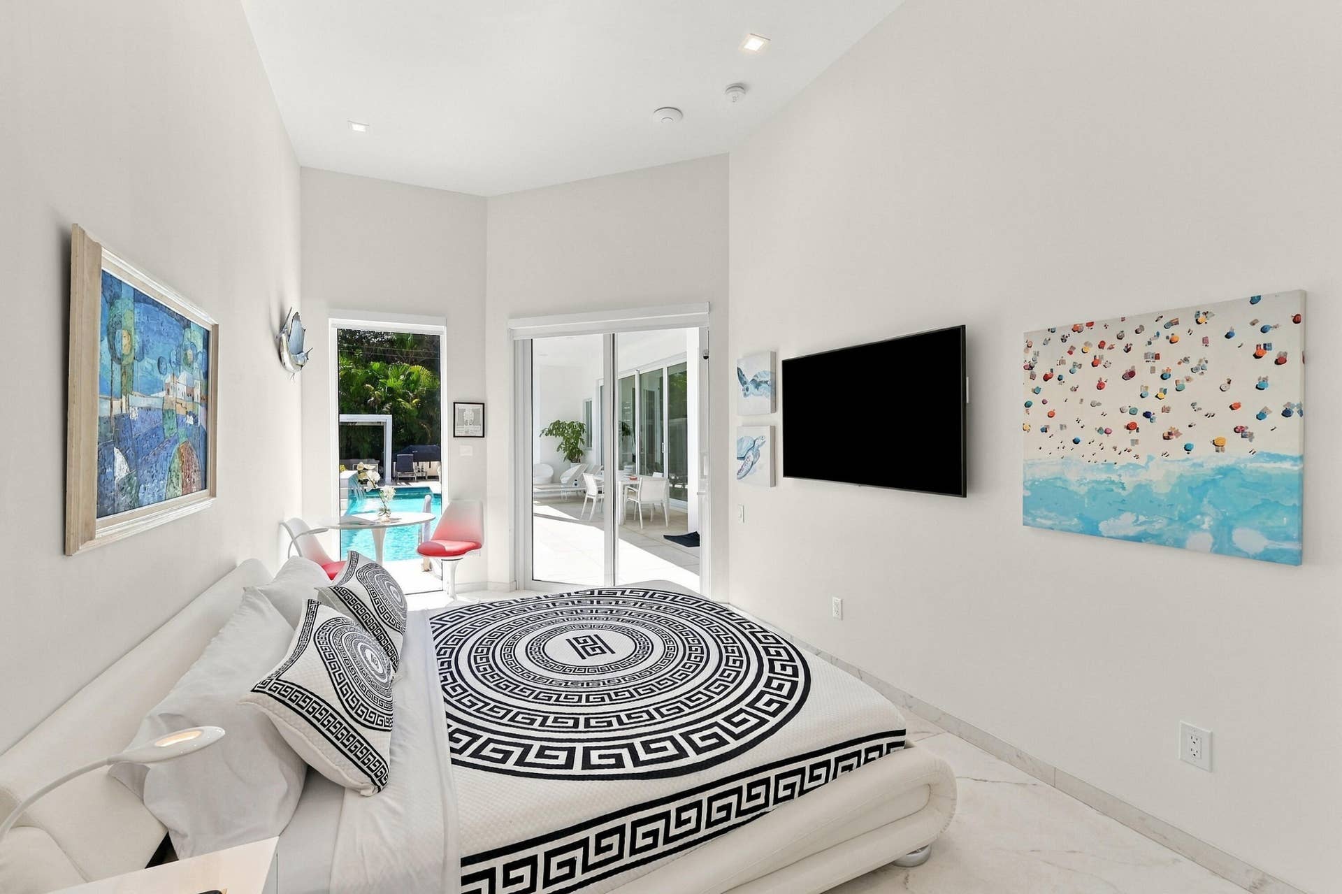110 NE 16TH Place, Fort Lauderdale, FL 33305 White walls, recessed lighting, white marble-look flooring, glass sliding doors, and an outdoor swimming pool