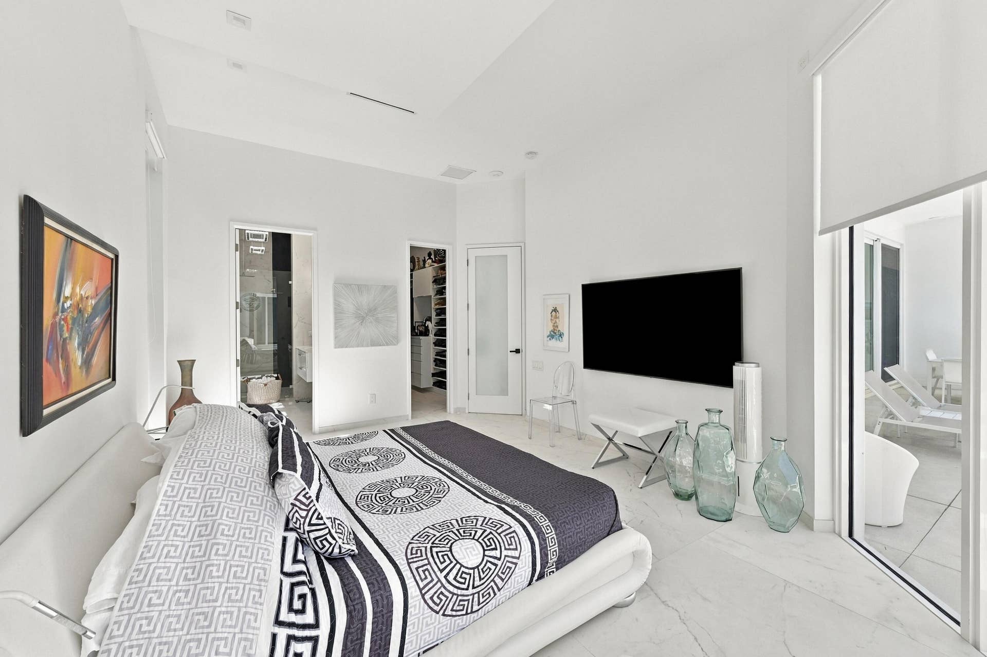 110 NE 16TH Place, Fort Lauderdale, FL 33305 Recessed lighting, marble-finish flooring, full-height sliding glass doors, white walls, and a recessed ceiling feature