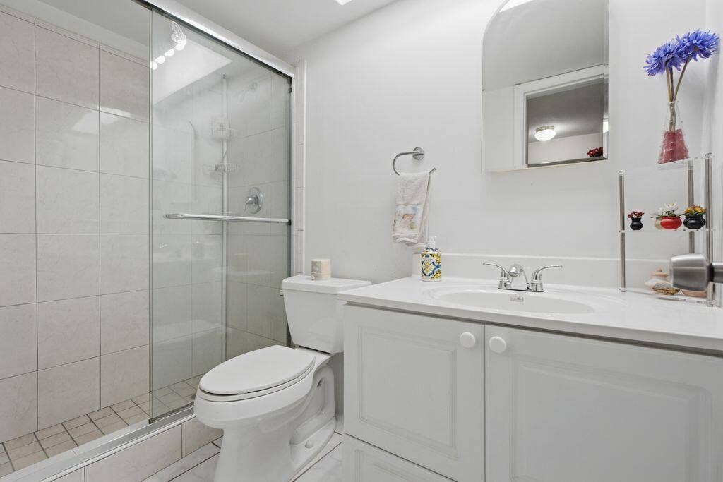 Second bath has step in shower with slider glass door
