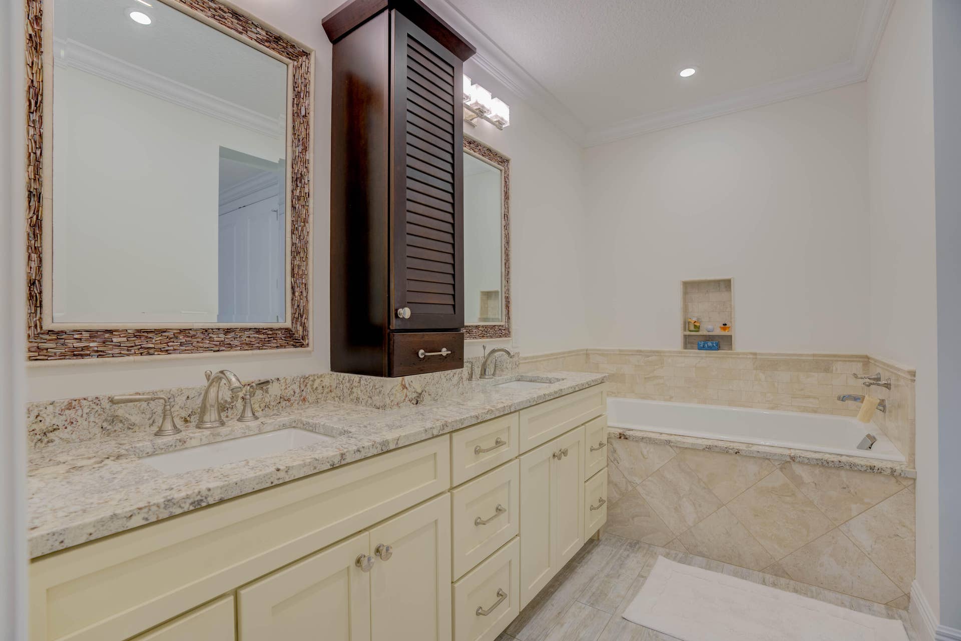 2043 Staysail Lane, Jupiter, Jupiter, FL 33477 Dual vanity with granite countertops, built-in storage cabinet, inset bathtub, and tiled surround