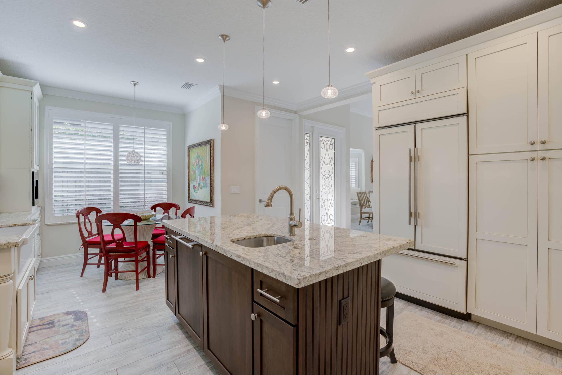 2043 Staysail Lane, Jupiter, Jupiter, FL 33477 Gourmet kitchen featuring a central island with a built-in sink, stone countertops, integrated paneled appliances, and ample white cabinetry