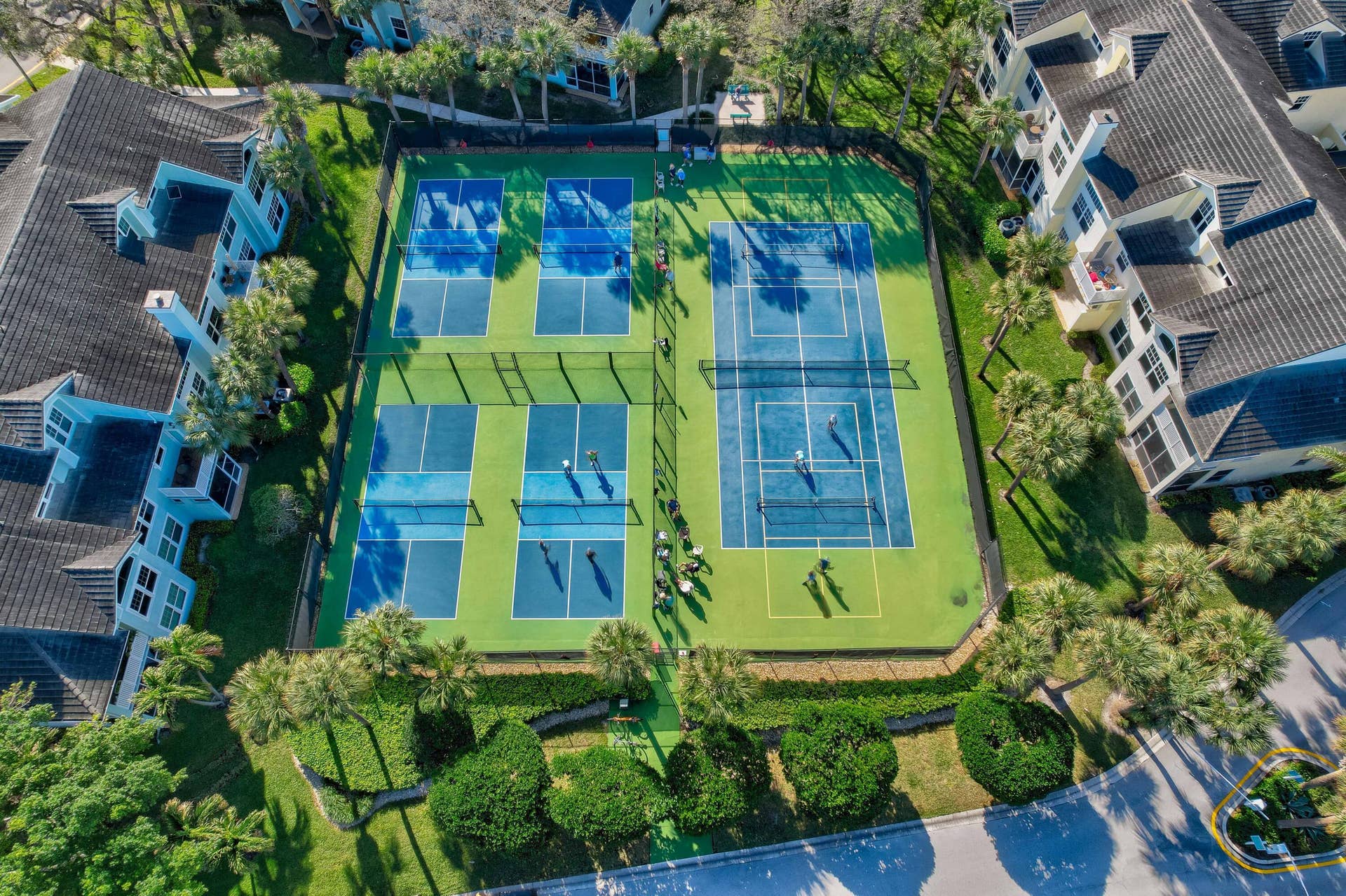 2043 Staysail Lane, Jupiter, Jupiter, FL 33477 Seven hard-surface courts, including five pickleball courts and two tennis courts, surrounded by manicured landscaping and mature palm trees