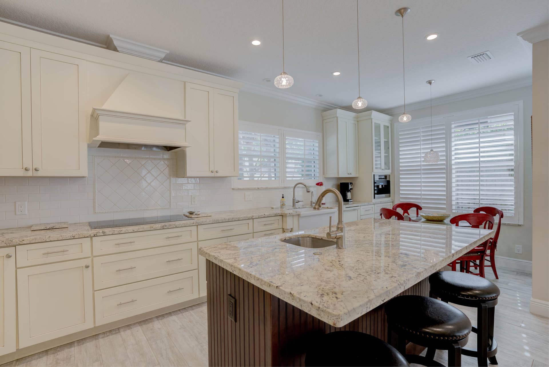 2043 Staysail Lane, Jupiter, Jupiter, FL 33477 Kitchen featuring a large island with granite countertop, cream-colored cabinetry, integrated cooktop, and multiple pendant lights