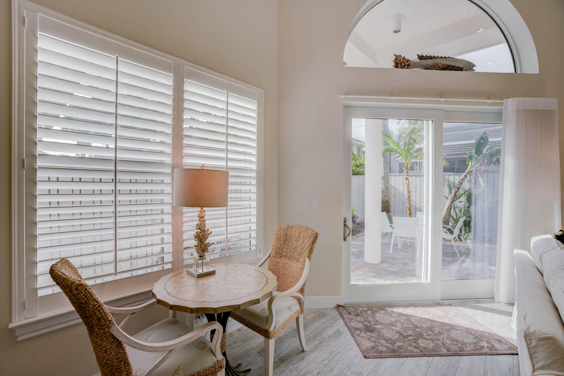 2043 Staysail Lane, Jupiter, Jupiter, FL 33477 Window shutters, arched transom window, wood-finish flooring, and sliding glass doors to a paved outdoor area