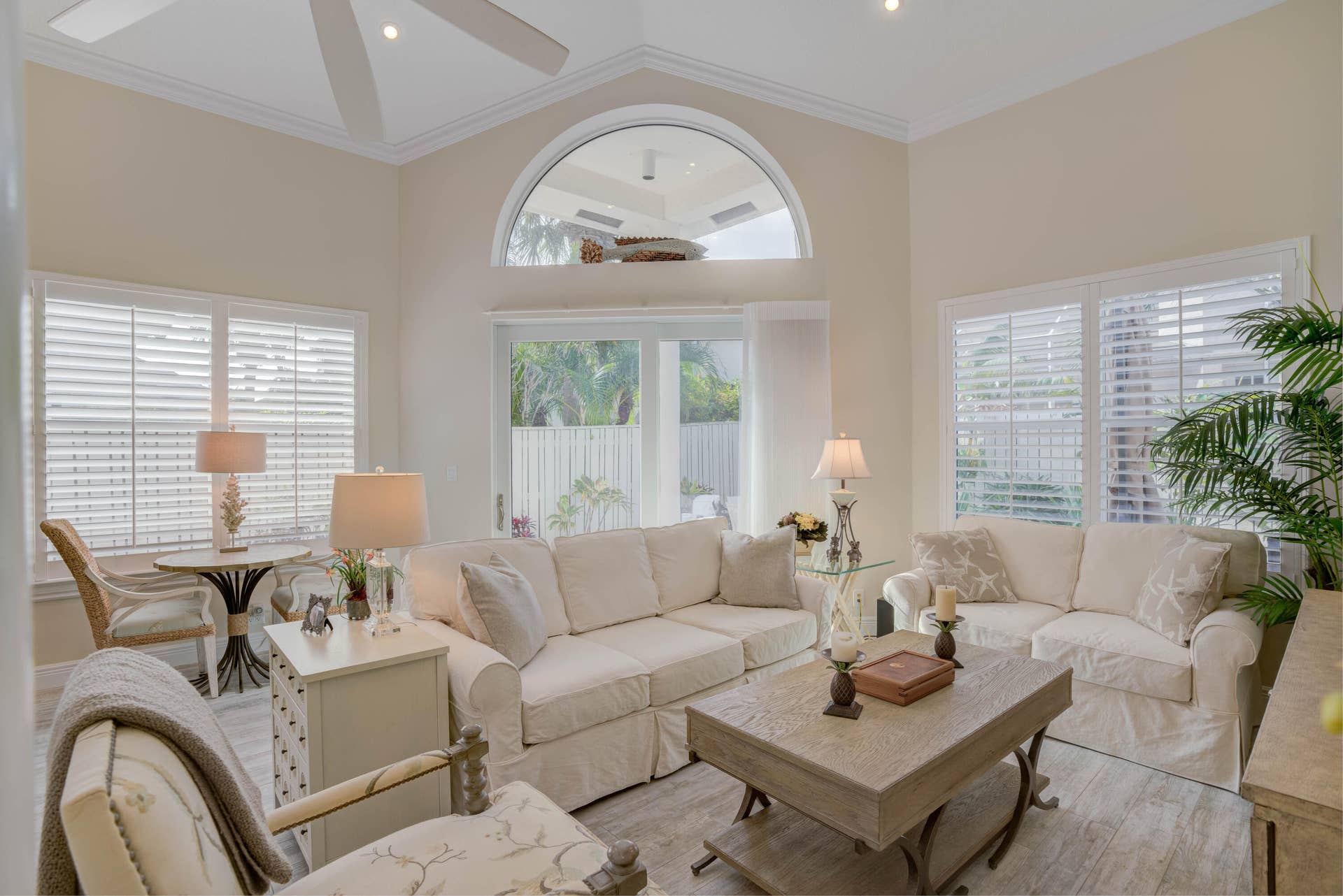 2043 Staysail Lane, Jupiter, Jupiter, FL 33477 Vaulted ceiling with an arched window, white plantation shutters, and wood-finish flooring
