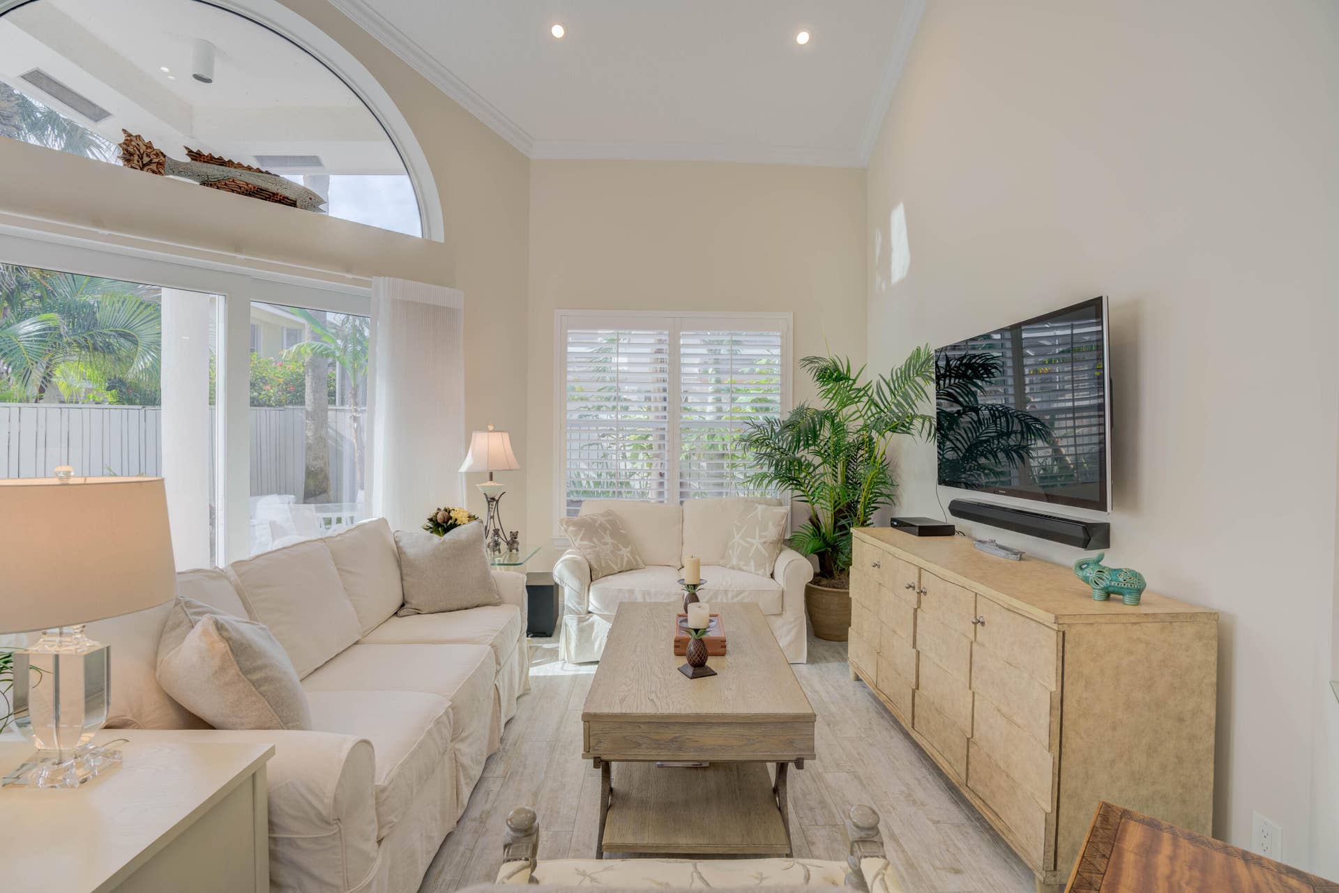 2043 Staysail Lane, Jupiter, Jupiter, FL 33477 Vaulted ceiling with recessed lighting, large arched window, wood-finish flooring, and white plantation shutters