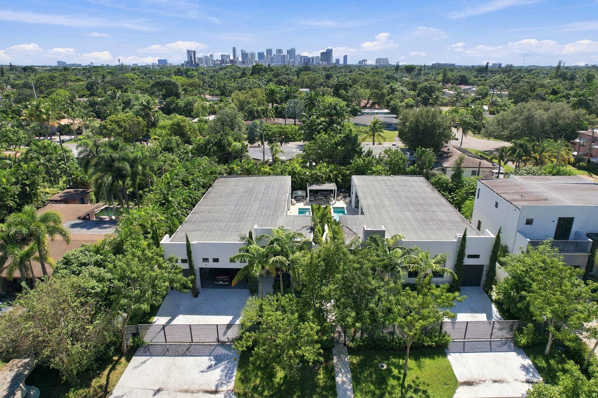Modern architecture featuring flat roofs, private driveways, and dense surrounding foliage