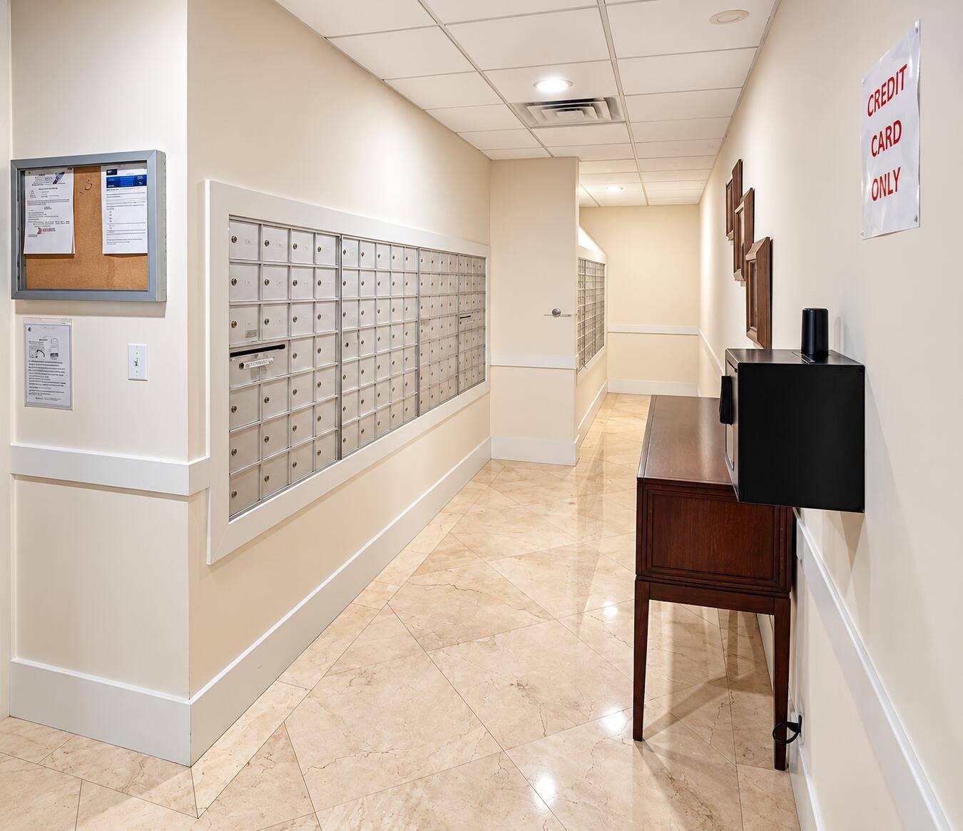 Hallway featuring a grid of mailboxes, recessed lighting, and light-toned tile flooring