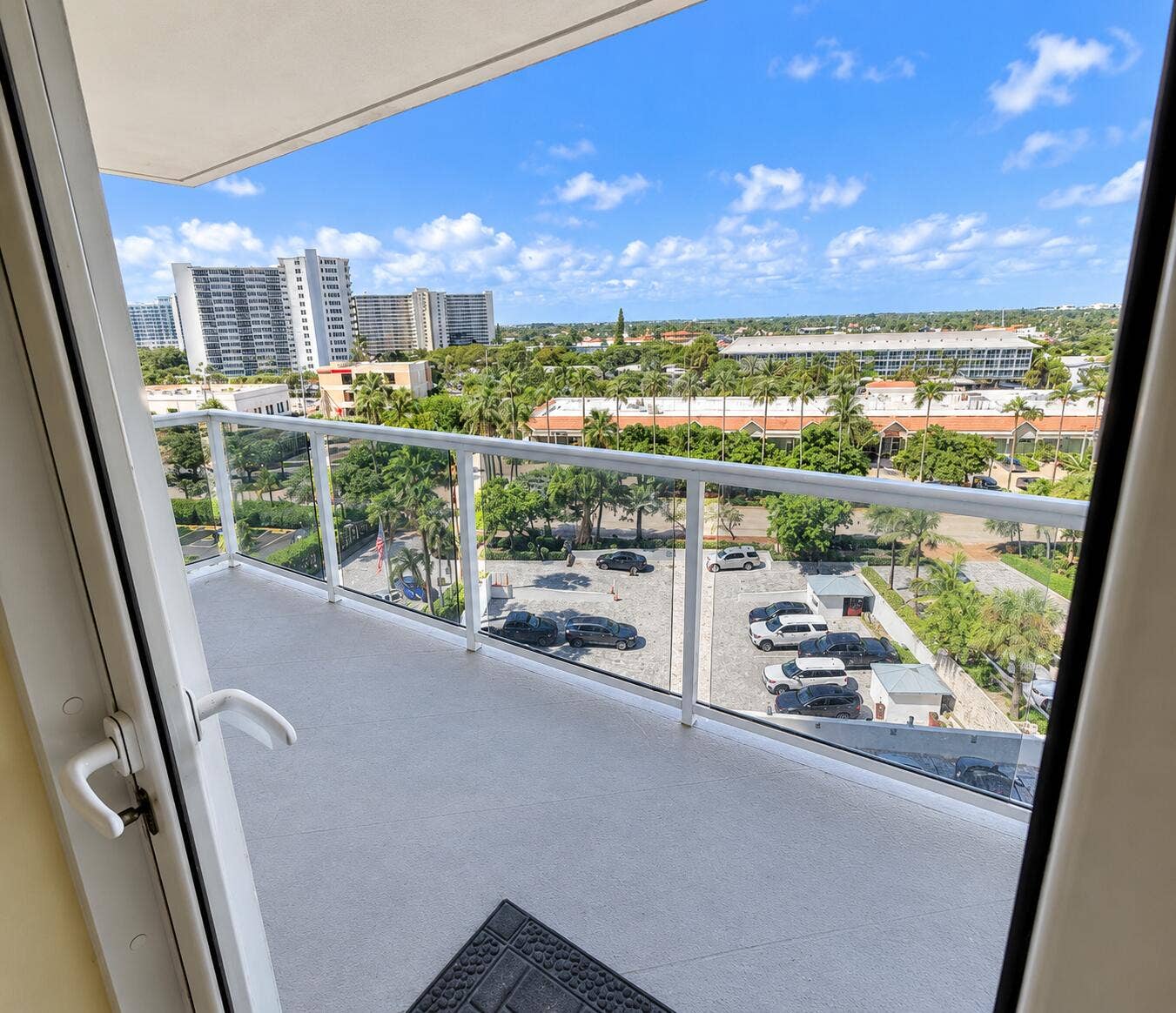 Balcony featuring a glass railing system and a concrete floor