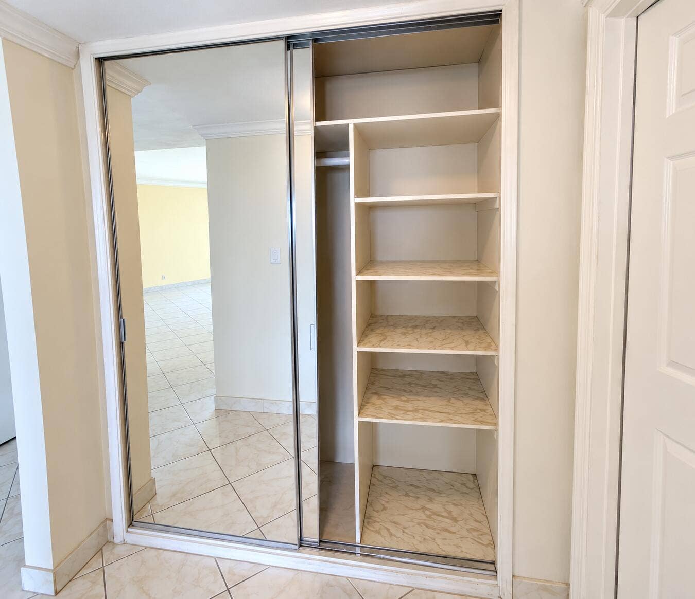 Built-in closet with mirrored sliding doors, integrated shelving, and hanging rod