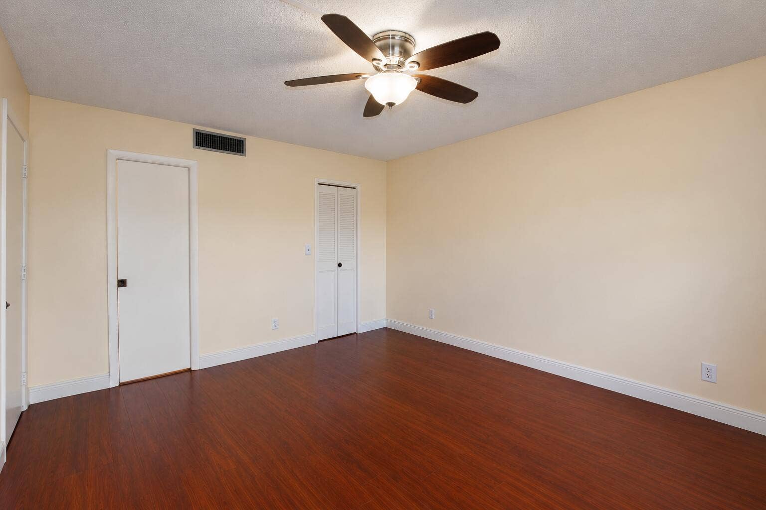 Empty Beige Bedroom with Ceiling Fan
