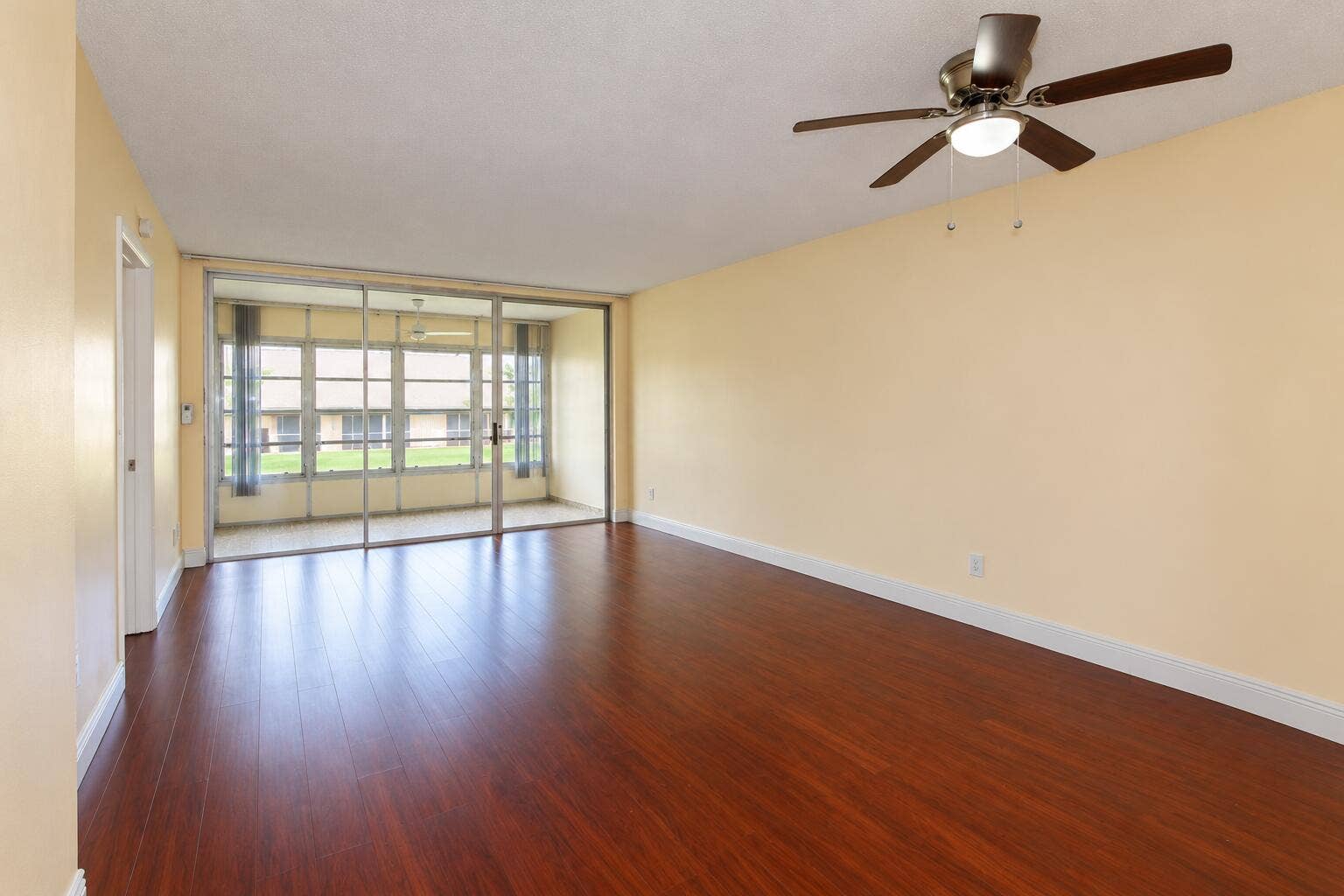 Empty Living Room with Sunroom Views