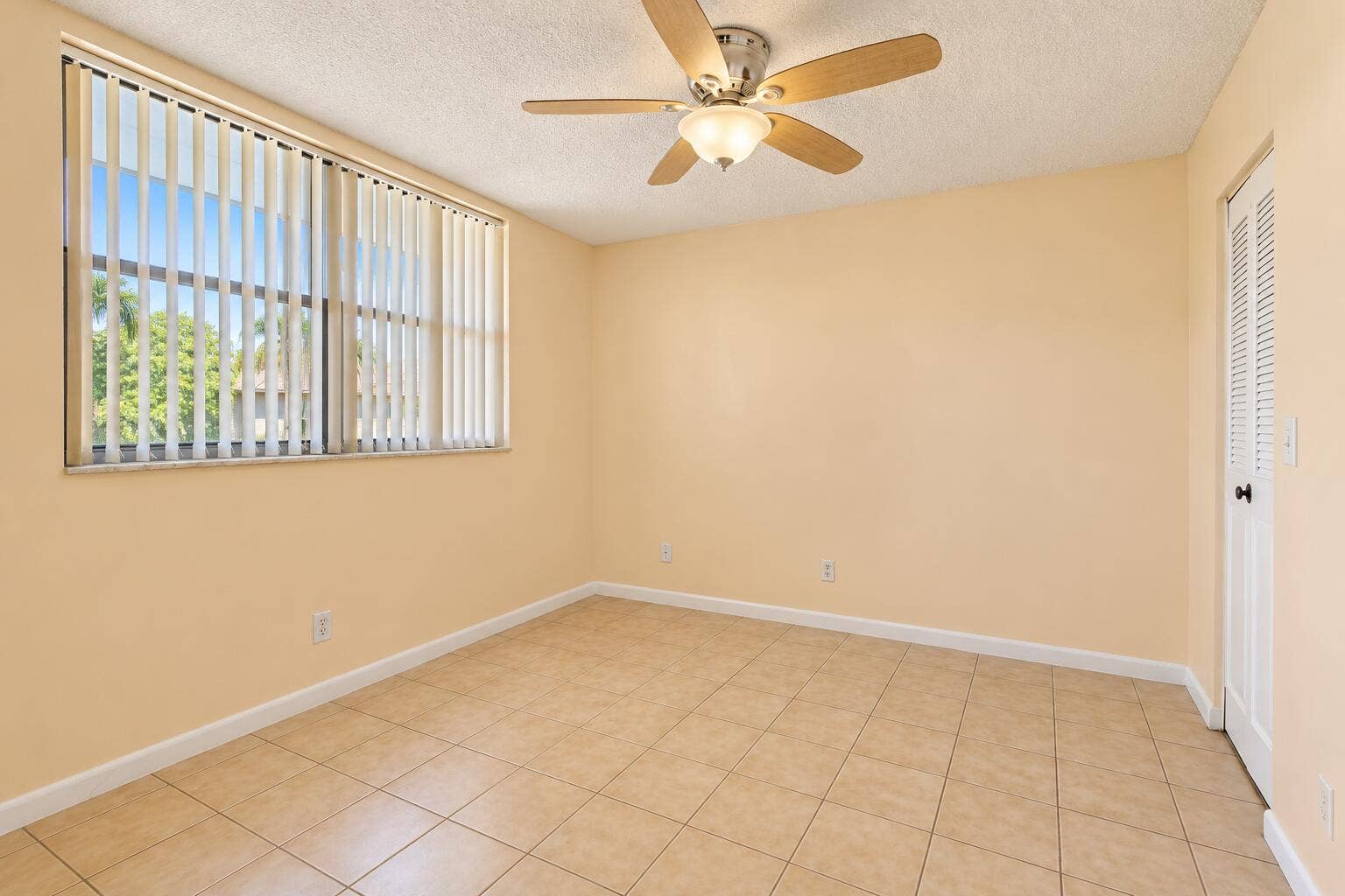 Bright Empty Beige-Tiled Bedroom