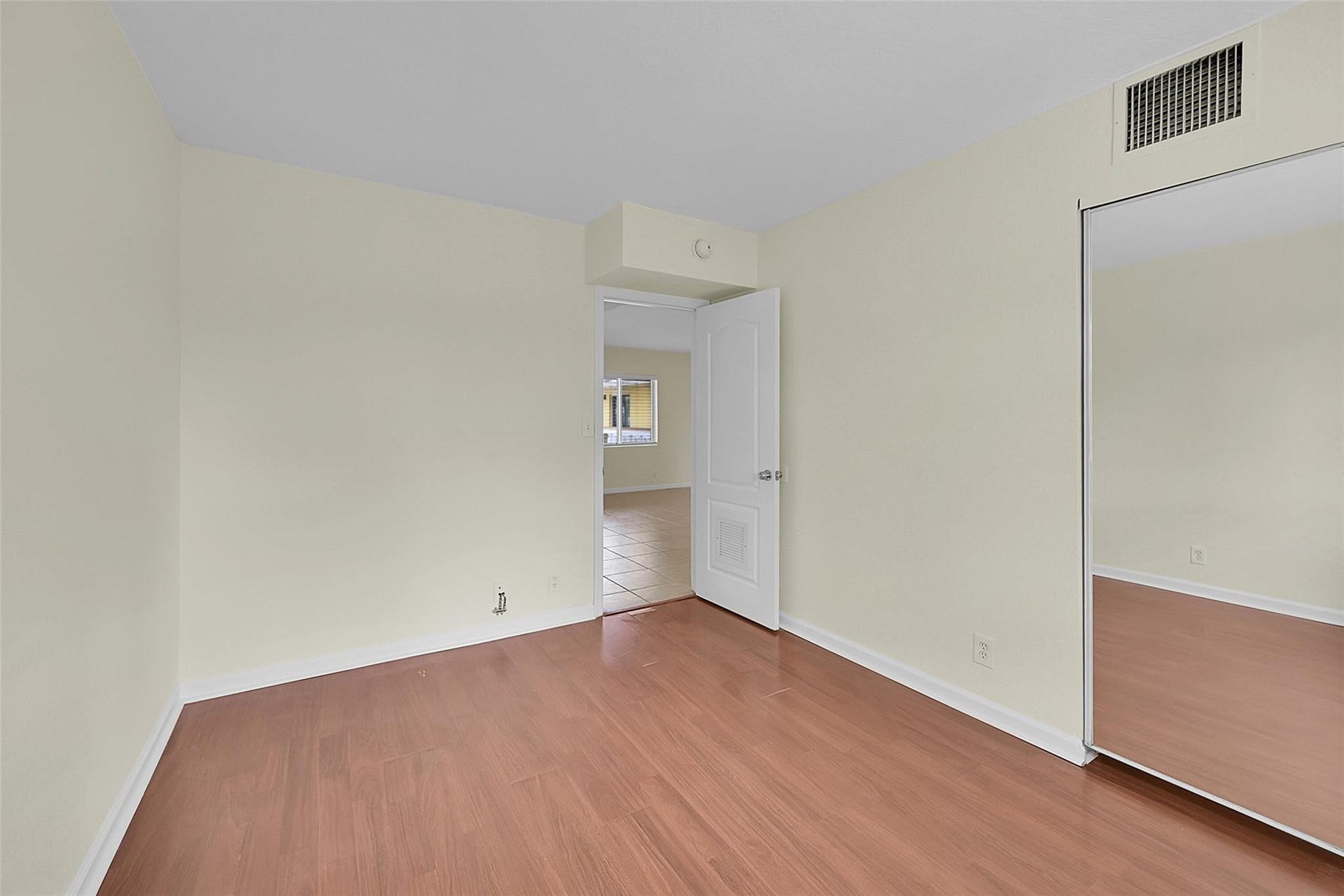 2655 NE 8th Avenue, #Apt 210, Wilton Manors, FL 33334 Wood-finish flooring, neutral wall tones, and a mirrored sliding closet door