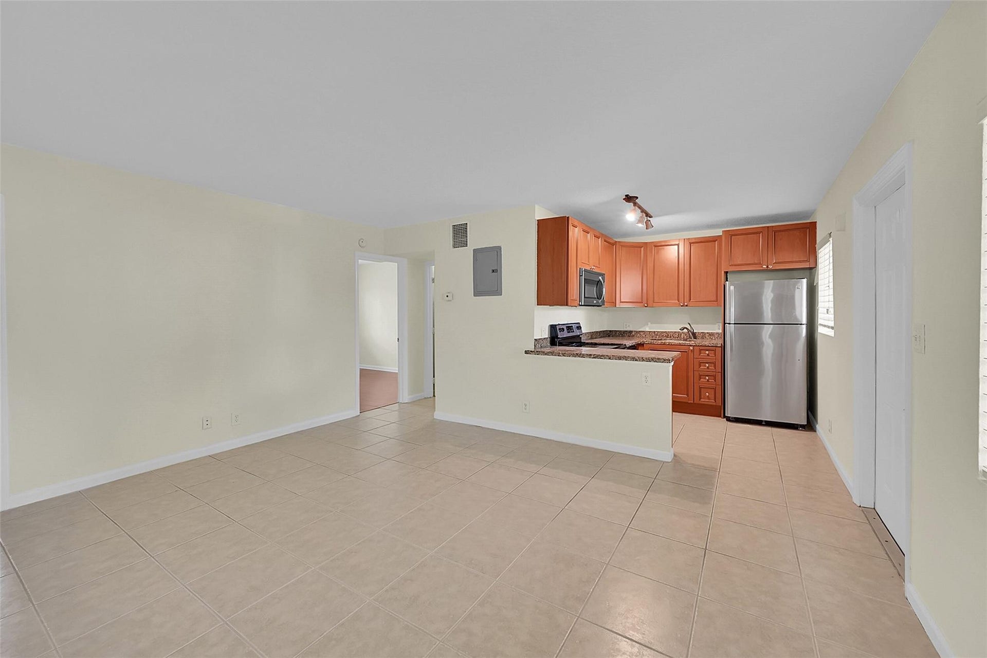 2655 NE 8th Avenue, #Apt 210, Wilton Manors, FL 33334 Kitchen with wood-finish cabinetry, stainless steel appliances, and granite-style countertops
