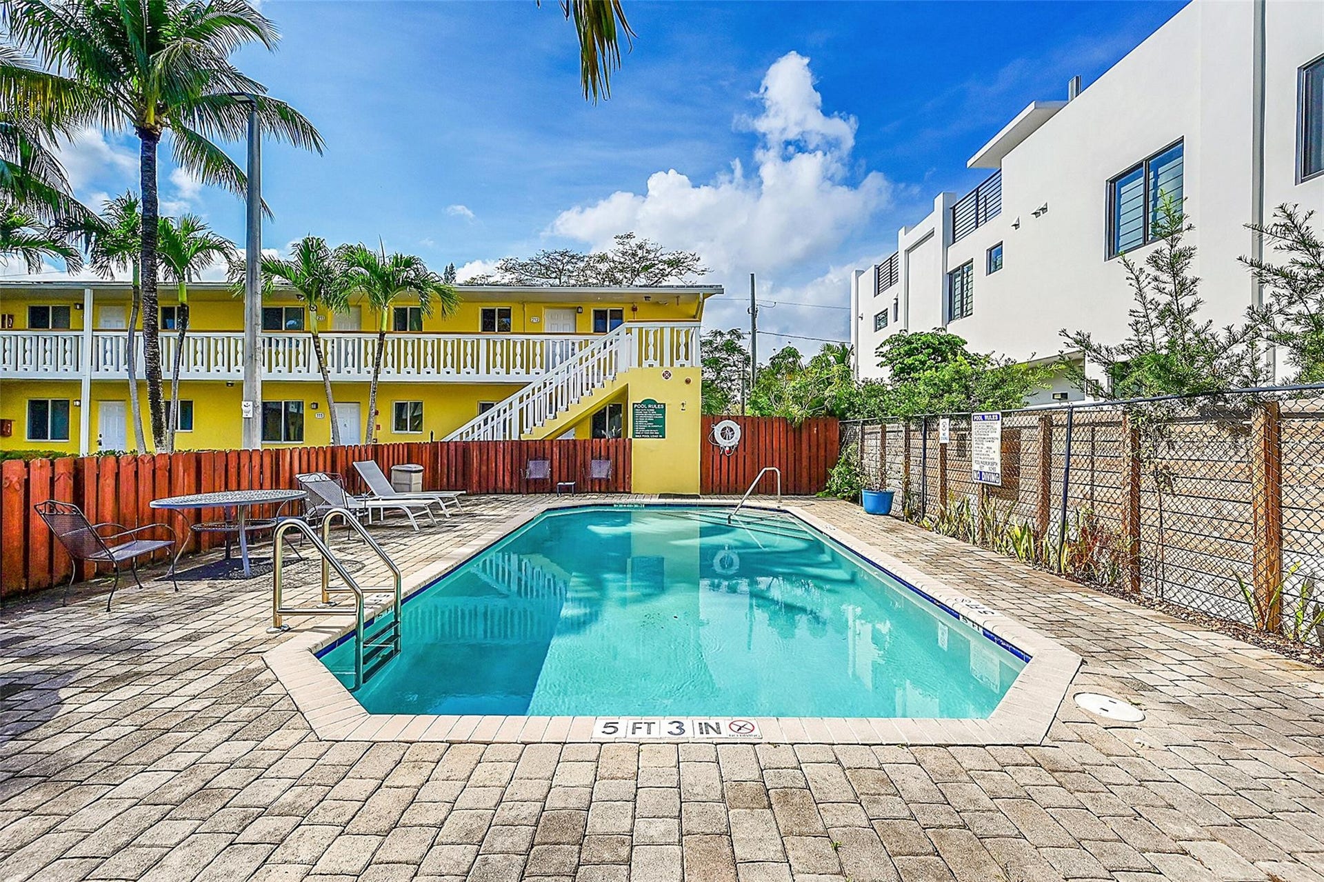 2655 NE 8th Avenue, #Apt 210, Wilton Manors, FL 33334 Outdoor swimming pool with integrated entry steps, surrounded by paver patio surfacing, and secured by a perimeter fence