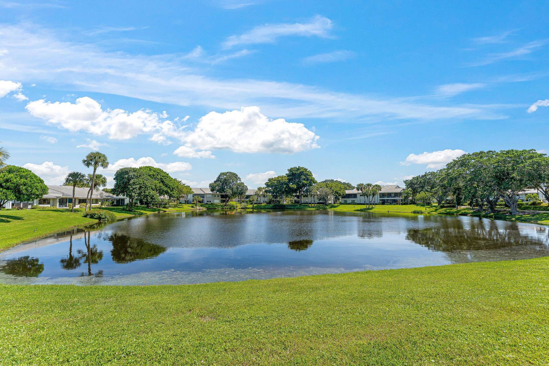 Expansive water feature bordered by green lawn and mature trees