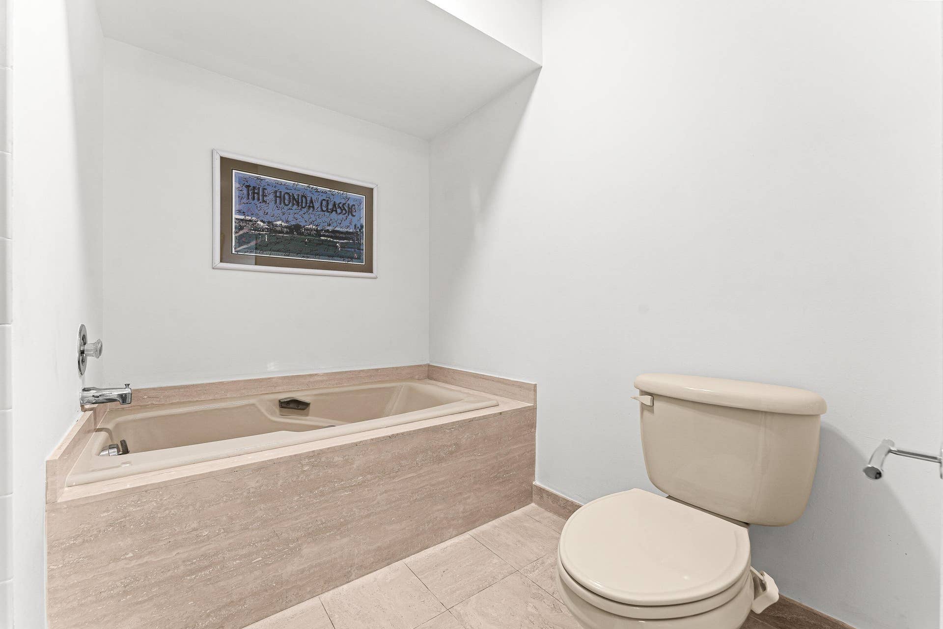 Built-in soaking tub with a stone-finish surround, complemented by tiled flooring