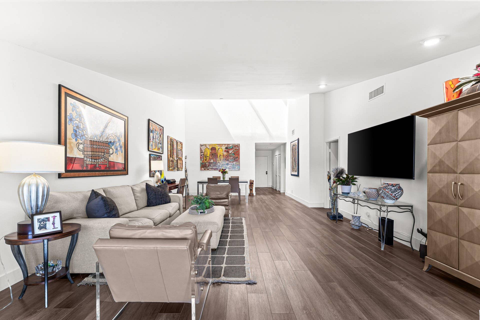 Wood-finish flooring, recessed lighting, and high ceilings create an expansive atmosphere