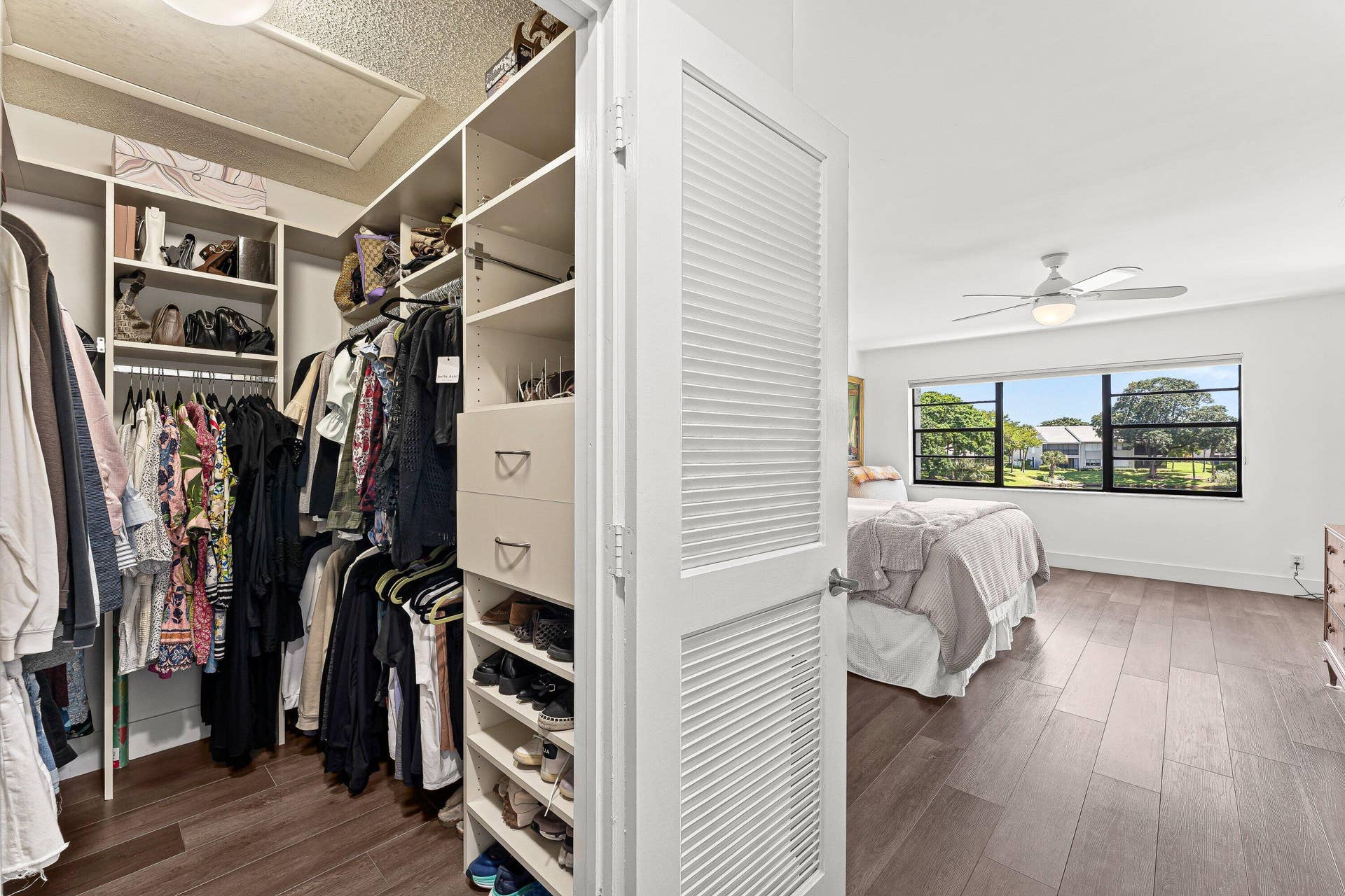 Walk-in closet with built-in shelving, drawers, and hanging rods