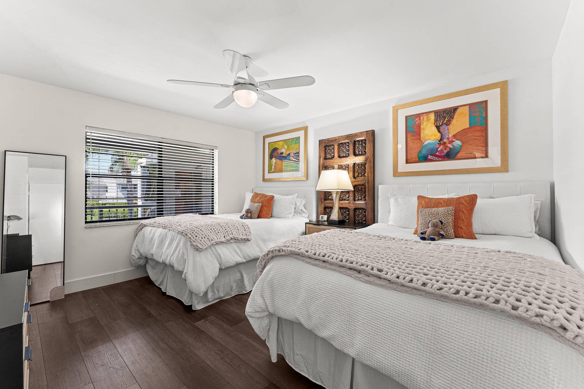 Wood-finish flooring, white walls, ceiling fan with integrated lighting, window with horizontal blinds, and a built-in headboard