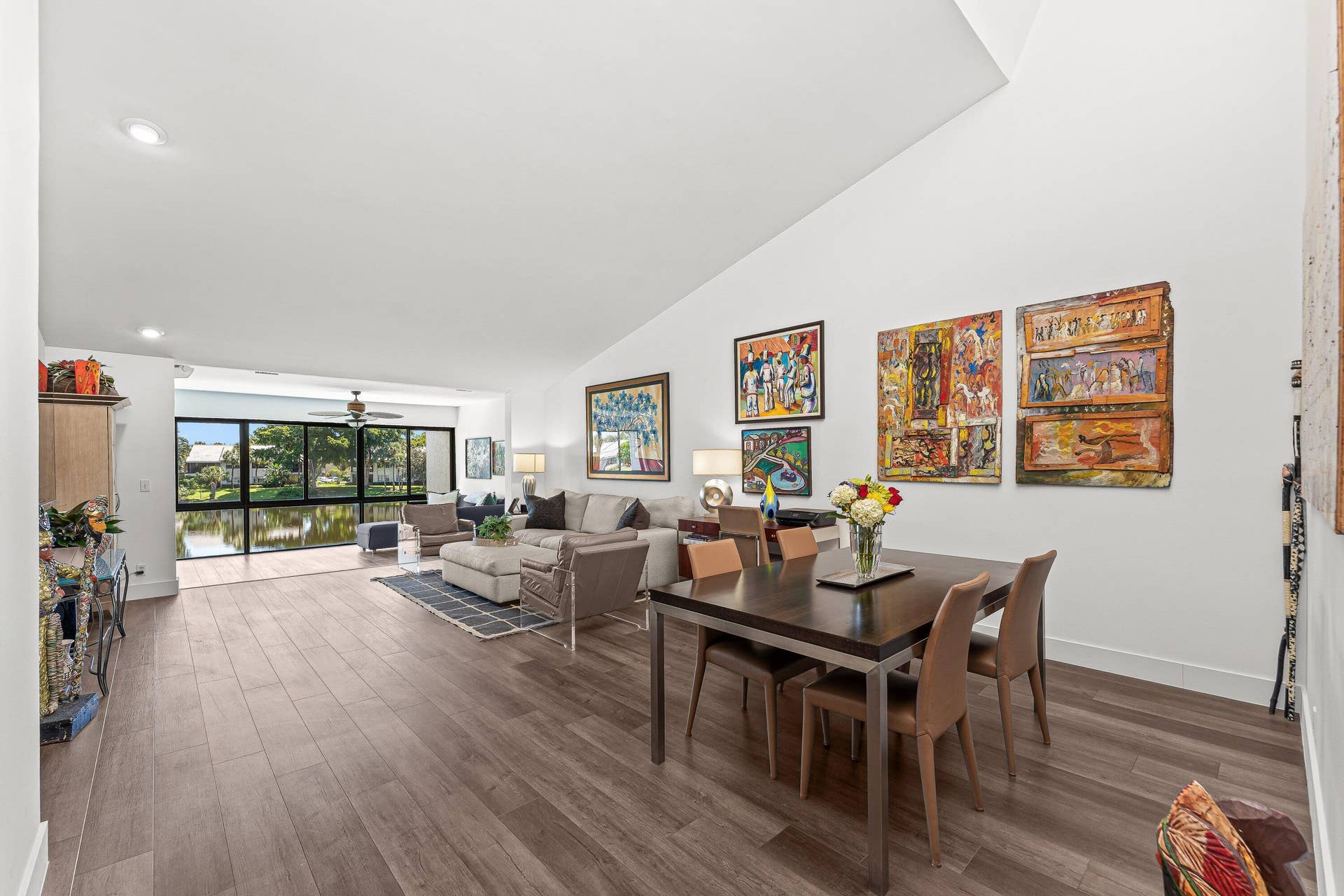 Vaulted ceilings with recessed lighting, wood-finish flooring, and large windows with transom panels