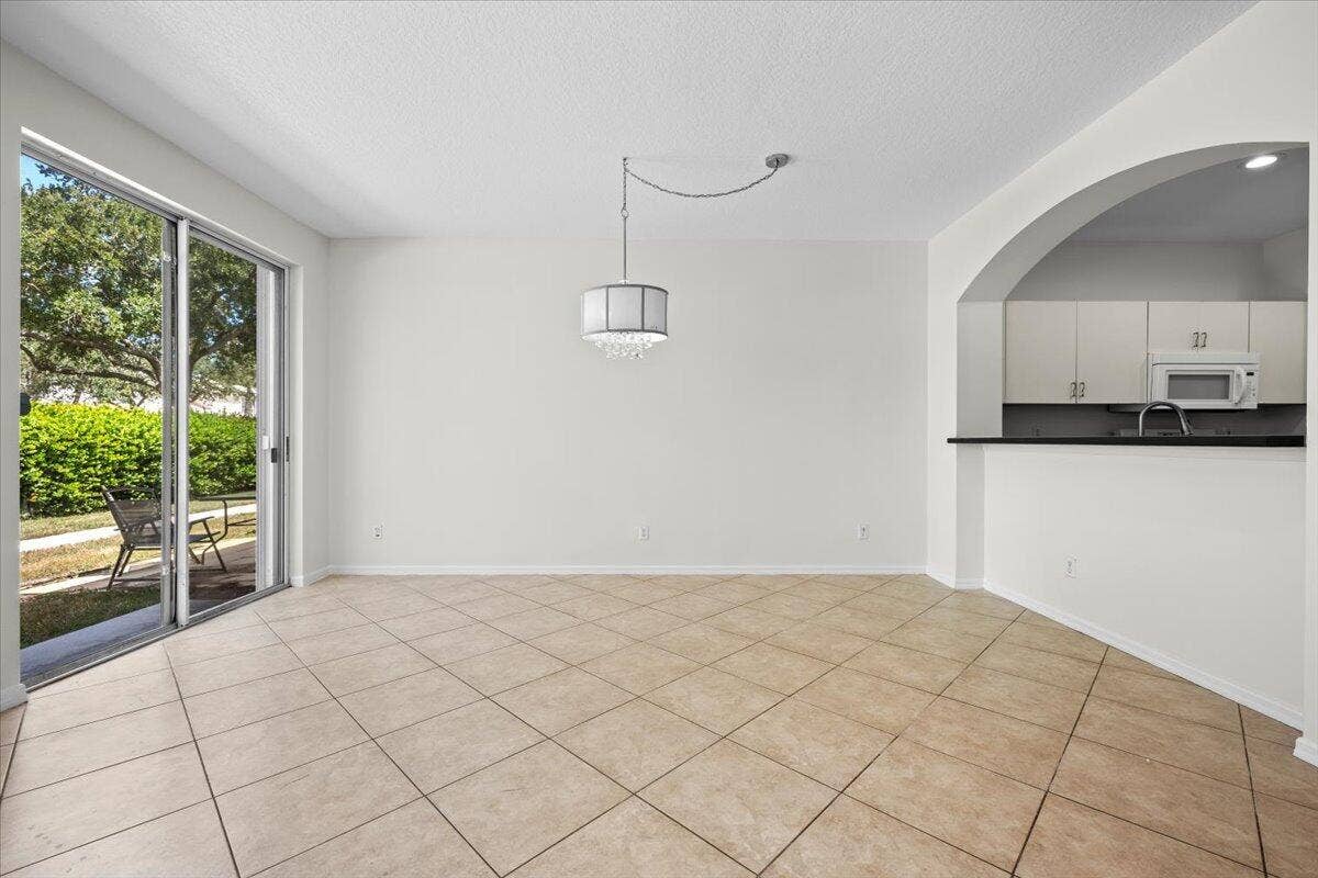 Bright dining area with tile flooring, sliding glass doors, and easy access to the kitchen.
