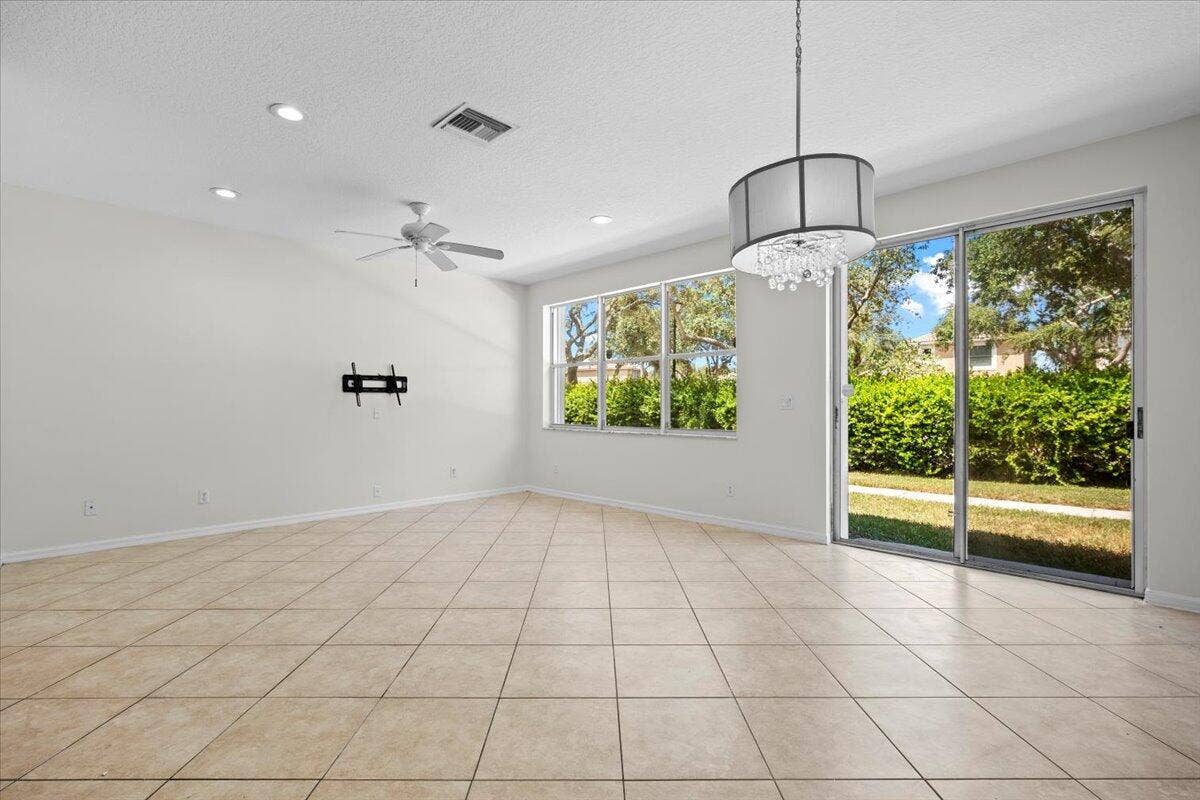 Spacious, open living area with tile flooring, natural light, and sliding glass doors.