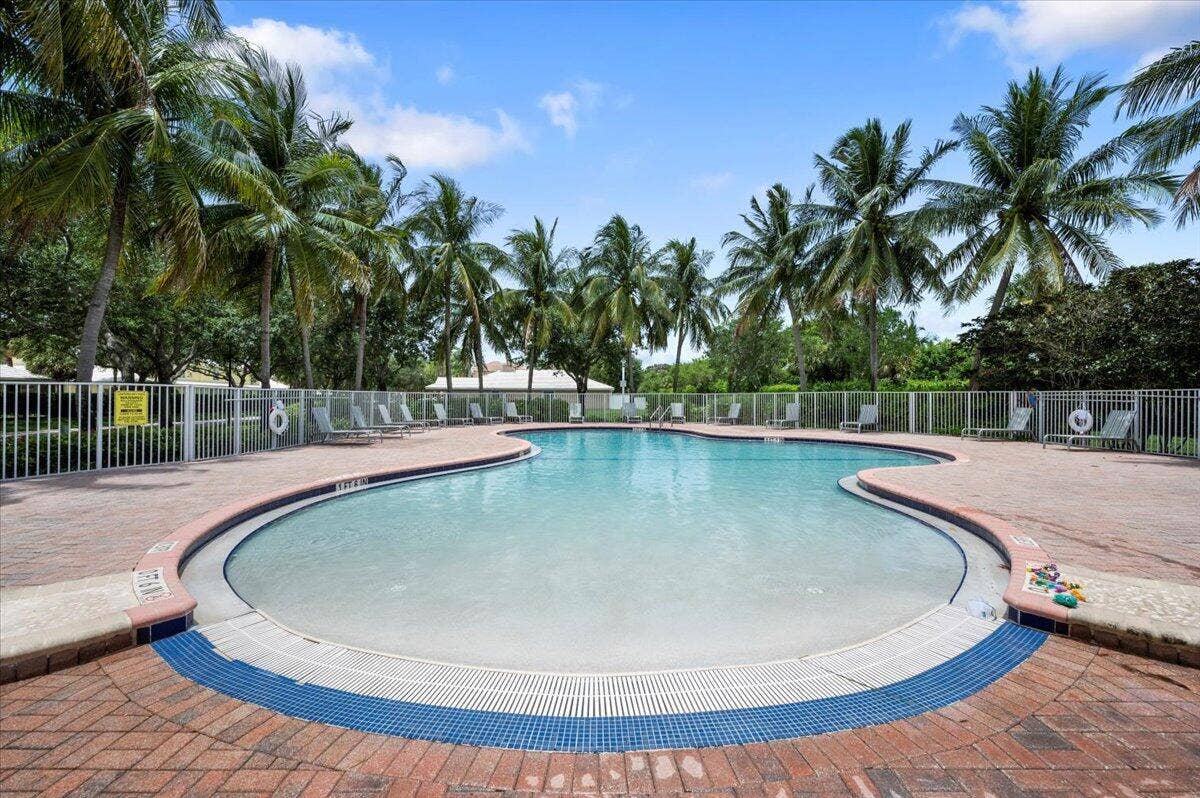 Enjoy the community swimming pool surrounded by palm trees and a spacious pool deck.