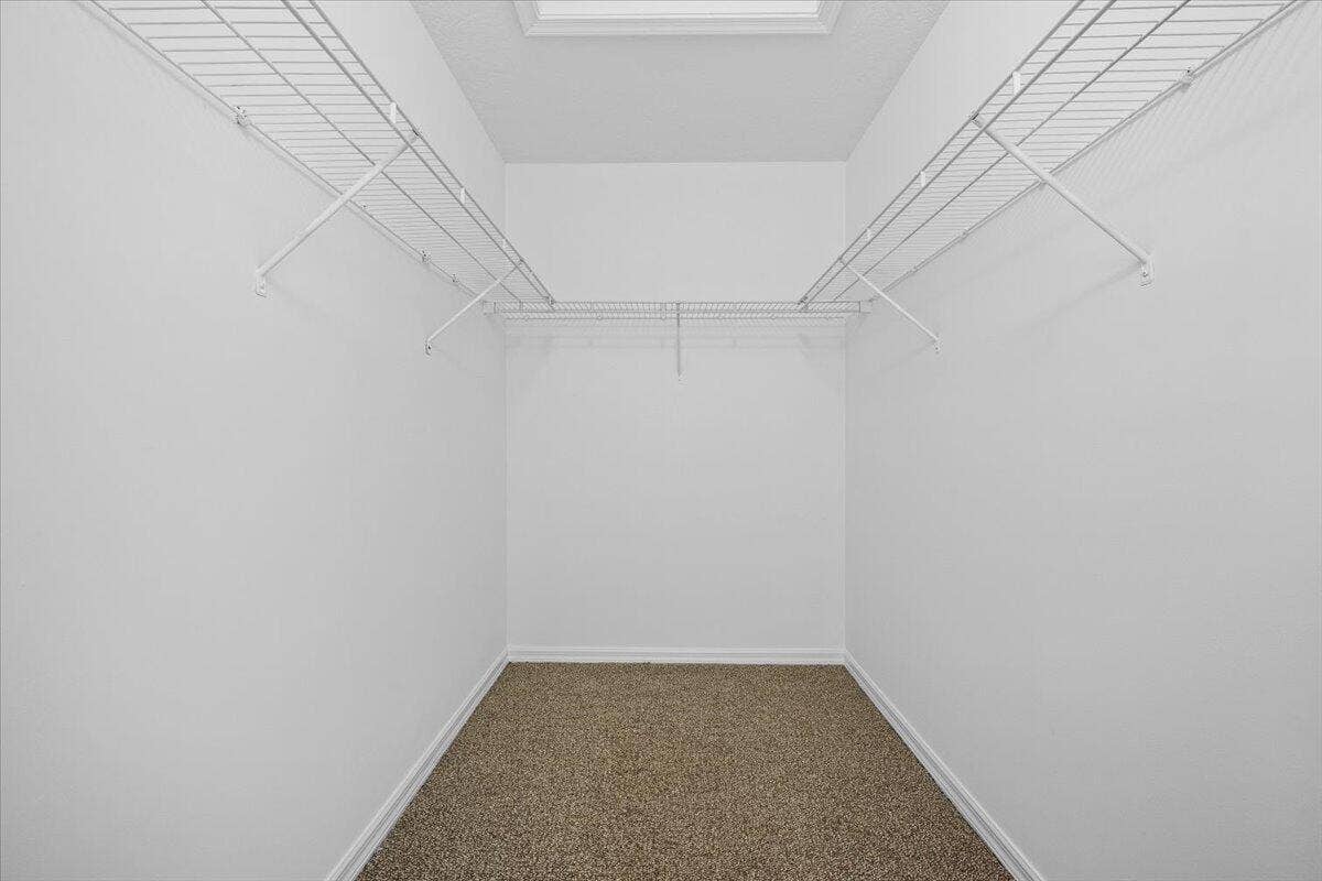 Generously sized walk-in closet with built-in shelving and plenty of storage space.