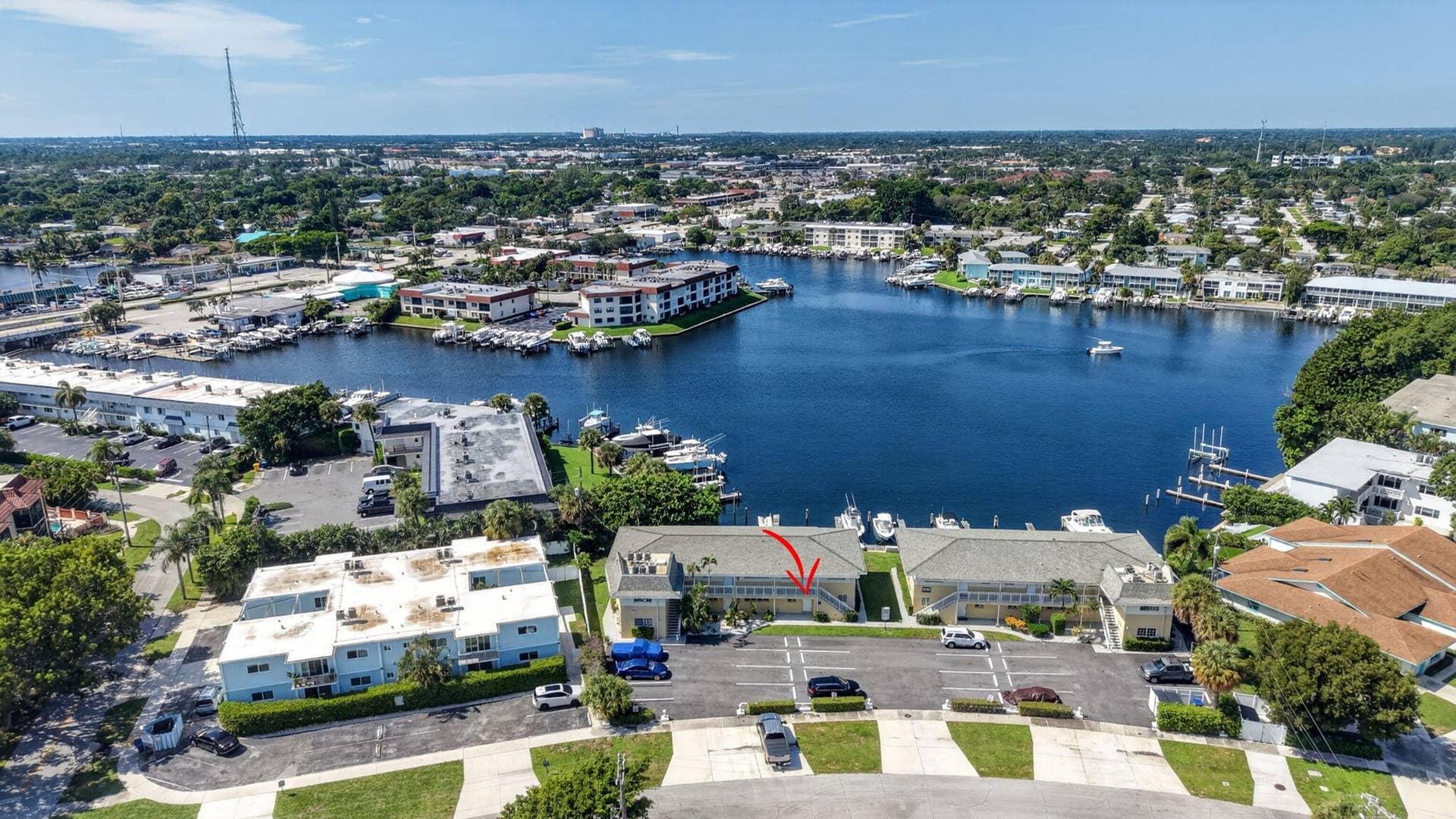 405 SOUTHWIND Drive, #3, North Palm Beach, FL 33408 Aerial perspective of multi-family property featuring a waterfront location, paved parking area, and mature landscaping