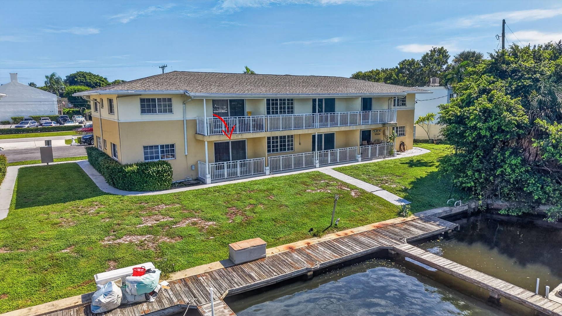 405 SOUTHWIND Drive, #3, North Palm Beach, FL 33408 Multi-level residential building featuring exterior balconies with metal railings, a shingled roof, and direct access to a private wooden boat dock