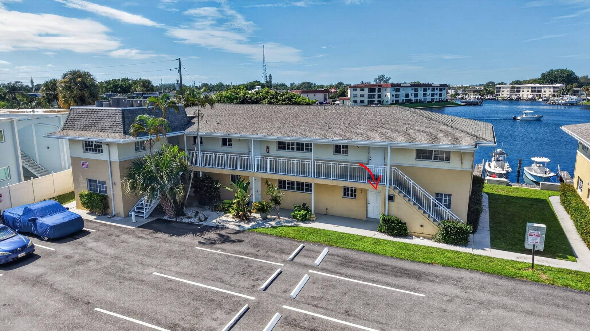 405 SOUTHWIND Drive, #3, North Palm Beach, FL 33408 Two-story multi-unit exterior featuring a shingled hip roof, second-level balcony with metal railing, and direct water frontage on a canal