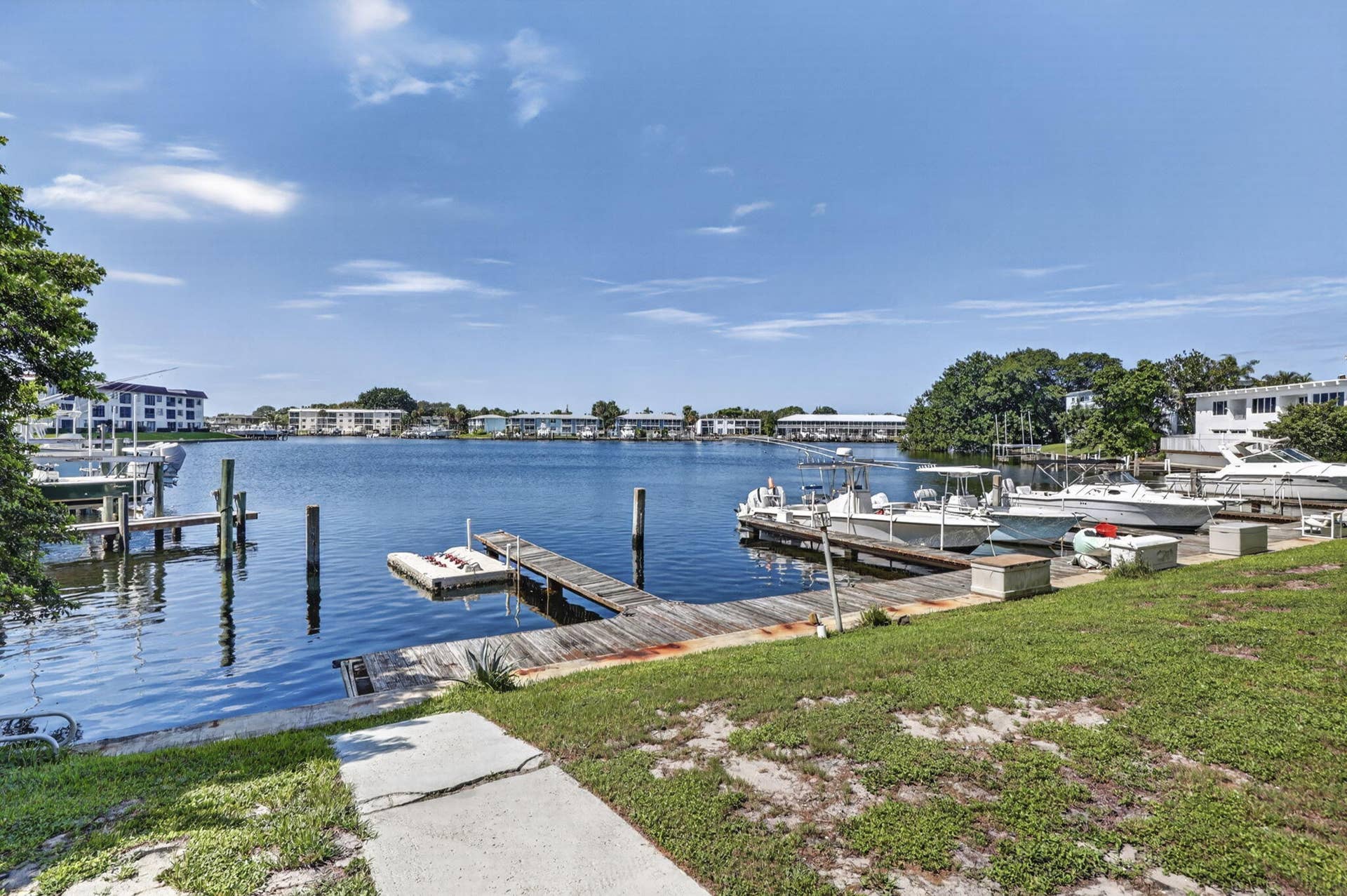 405 SOUTHWIND Drive, #3, North Palm Beach, FL 33408 Waterfront property featuring a private wooden dock, concrete boat slip, and direct access to an expansive canal
