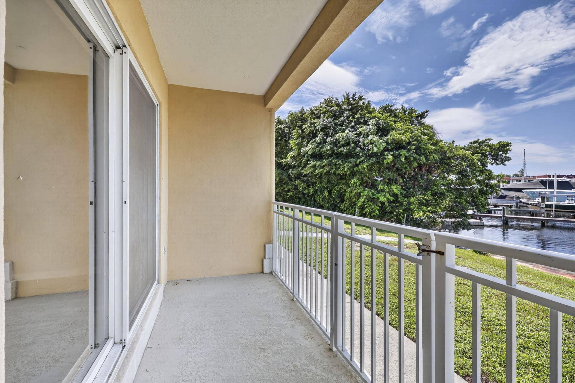 405 SOUTHWIND Drive, #3, North Palm Beach, FL 33408 Covered balcony featuring concrete flooring, a white metal railing, and sliding glass door access