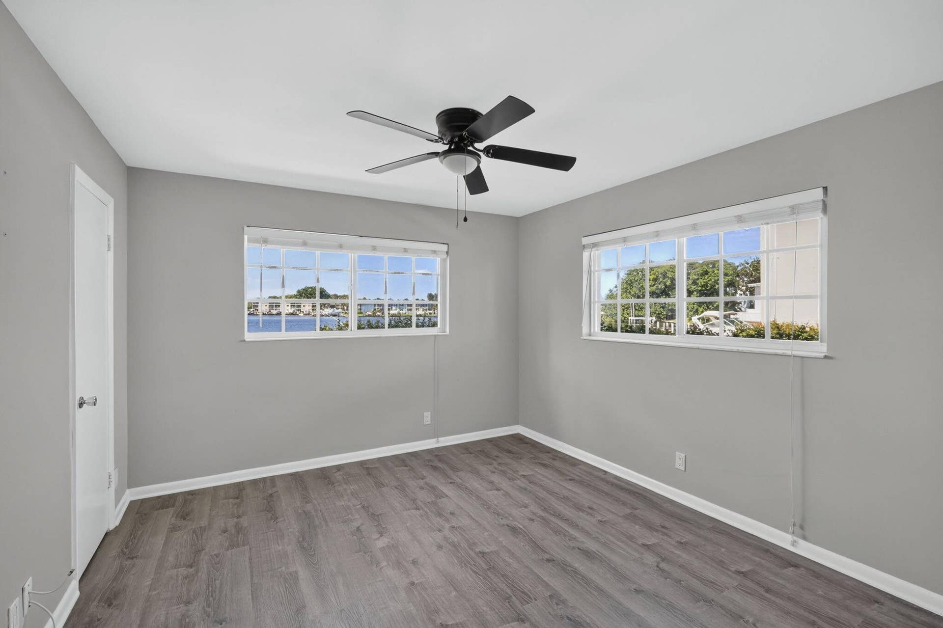 405 SOUTHWIND Drive, #3, North Palm Beach, FL 33408 Room featuring wood-finish flooring, dual windows with muntins, and a ceiling-mounted fan with integrated light fixture