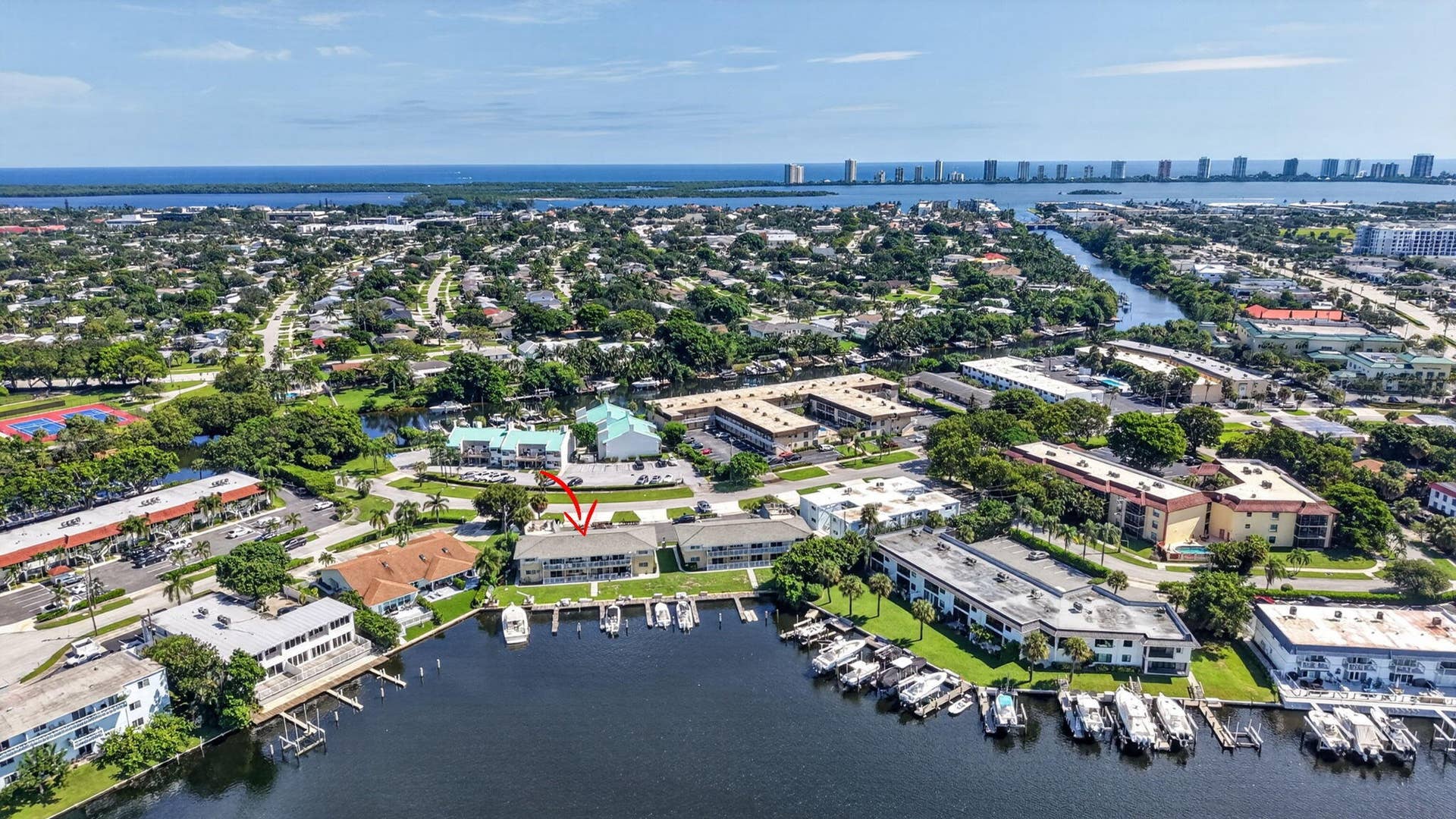 405 SOUTHWIND Drive, #3, North Palm Beach, FL 33408 Waterfront condominium building featuring private boat slips, multi-level balconies, and a canal-side location