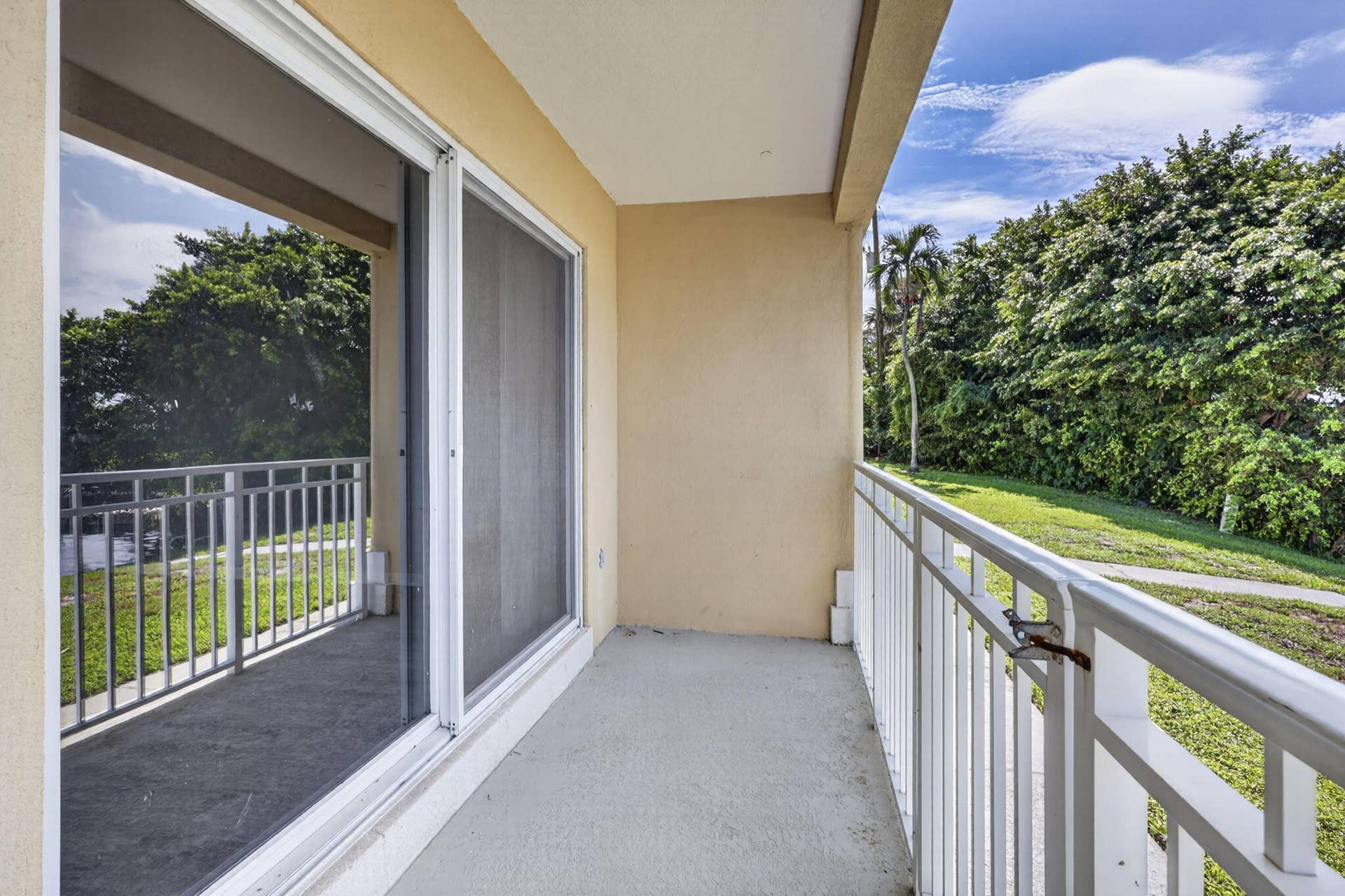 405 SOUTHWIND Drive, #3, North Palm Beach, FL 33408 Covered balcony featuring concrete flooring, white metal railings, and dual sliding glass doors with integrated screens