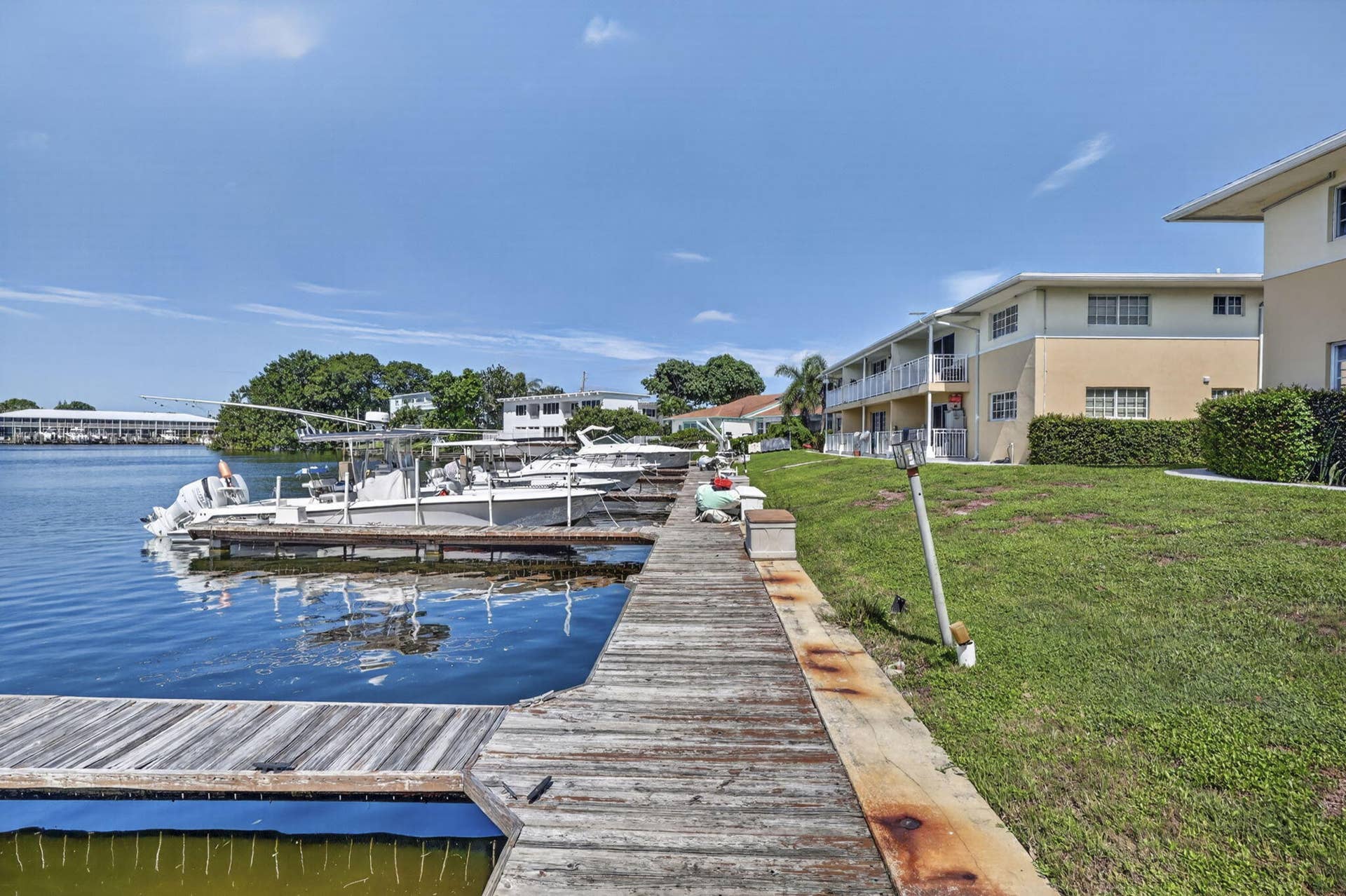 405 SOUTHWIND Drive, #3, North Palm Beach, FL 33408 Waterfront dock with multiple boat slips, wooden decking, and maintained lawn area