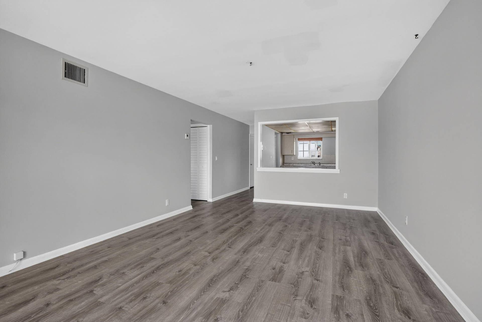 405 SOUTHWIND Drive, #3, North Palm Beach, FL 33408 Neutral interior featuring wood-finish flooring, light gray walls, and a recessed pass-through opening