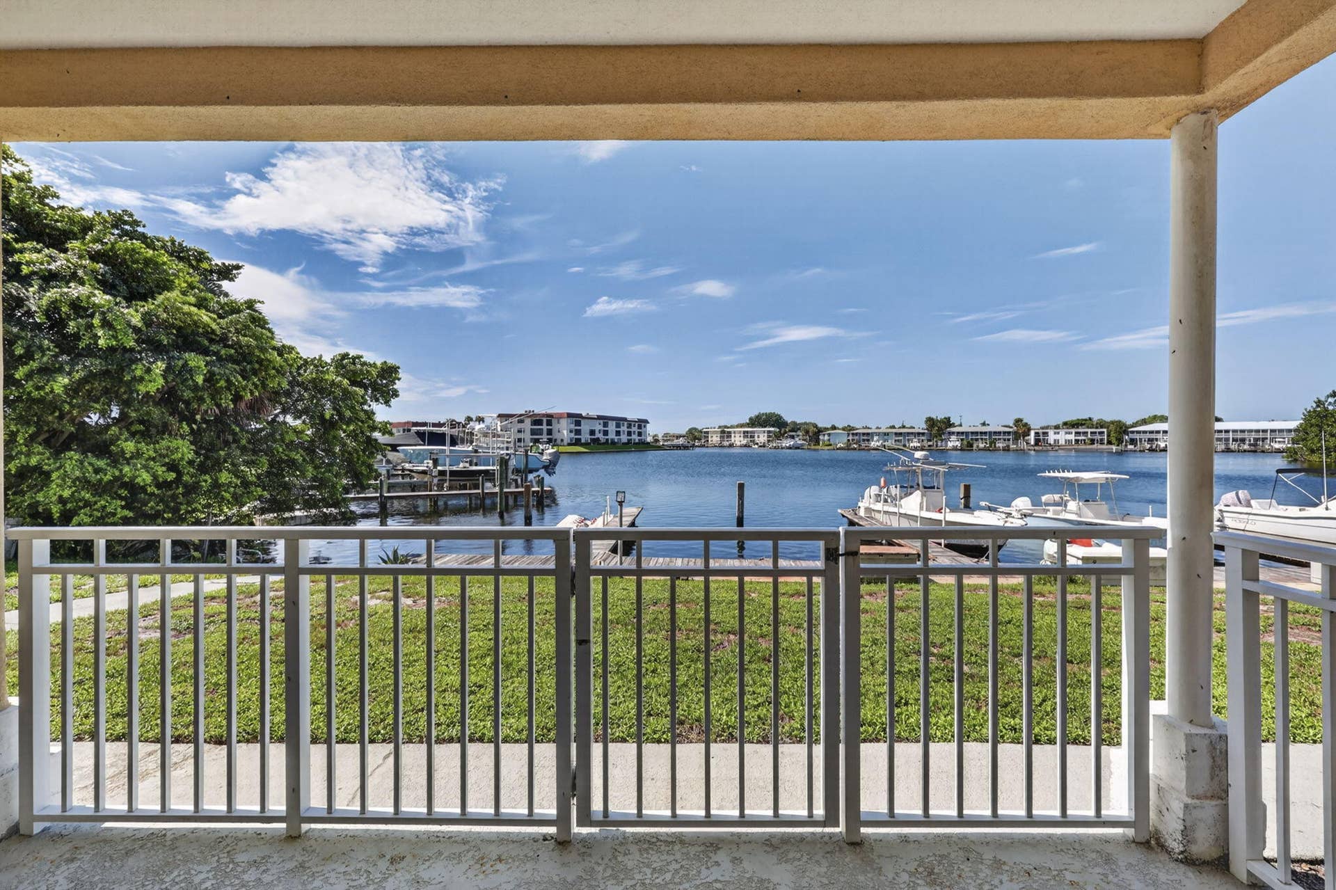 405 SOUTHWIND Drive, #3, North Palm Beach, FL 33408 Covered patio featuring white metal railings, concrete flooring, and direct water frontage with private boat slips