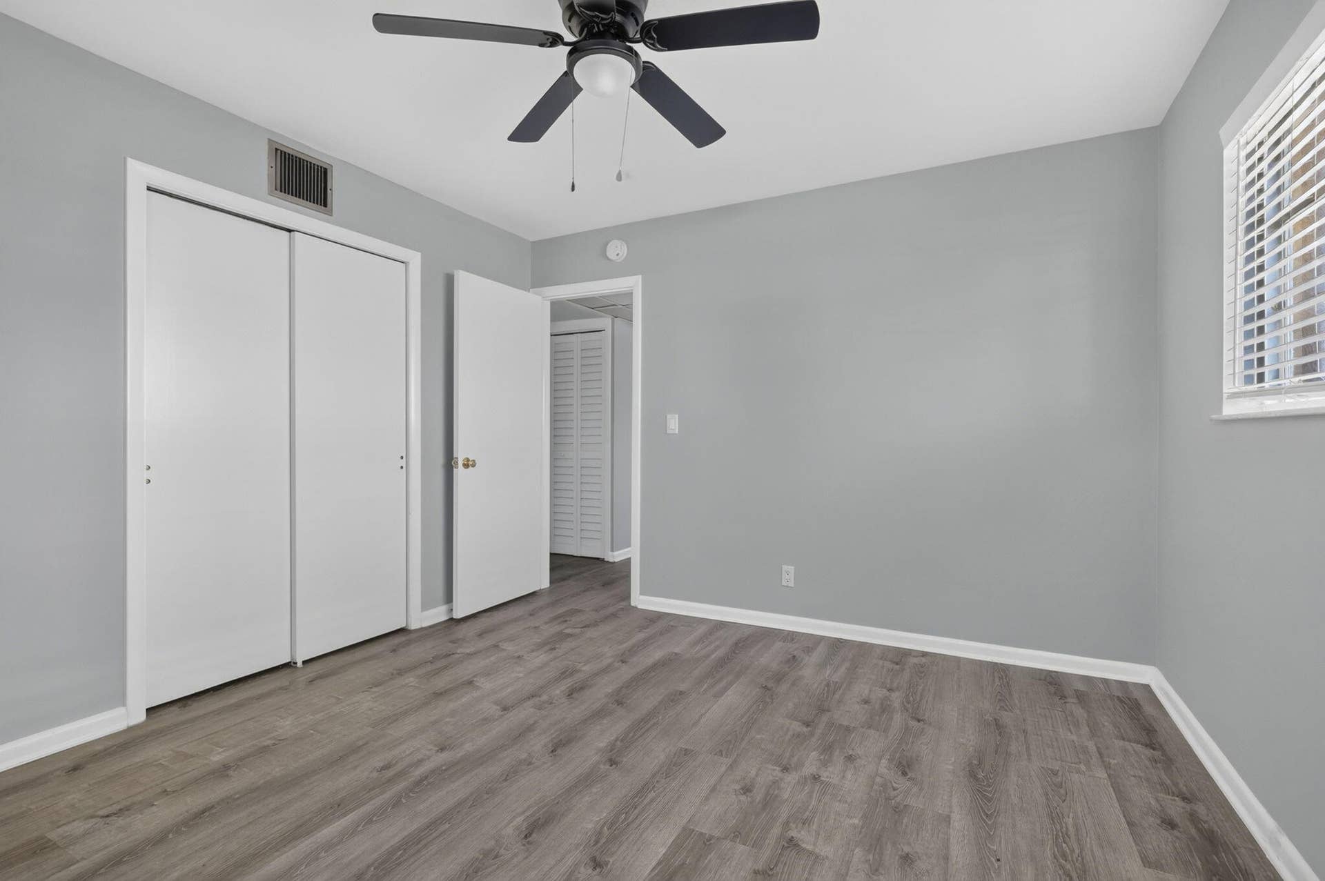 405 SOUTHWIND Drive, #3, North Palm Beach, FL 33408 Wood-finish flooring, neutral wall tones, sliding closet doors, and a ceiling-mounted light fixture with a fan