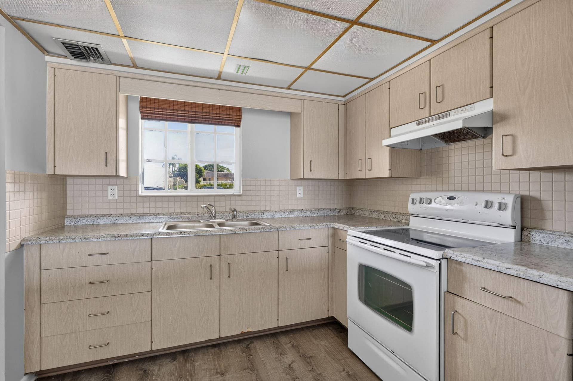 405 SOUTHWIND Drive, #3, North Palm Beach, FL 33408 Kitchen featuring light-finish cabinetry, speckled laminate countertops, ceramic tile backsplash, white range with overhead hood, and wood-finish flooring