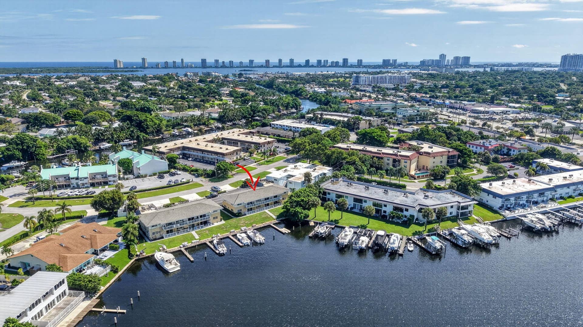 405 SOUTHWIND Drive, #3, North Palm Beach, FL 33408 Multi-level waterfront building featuring direct canal access, boat slips, and mature landscaping
