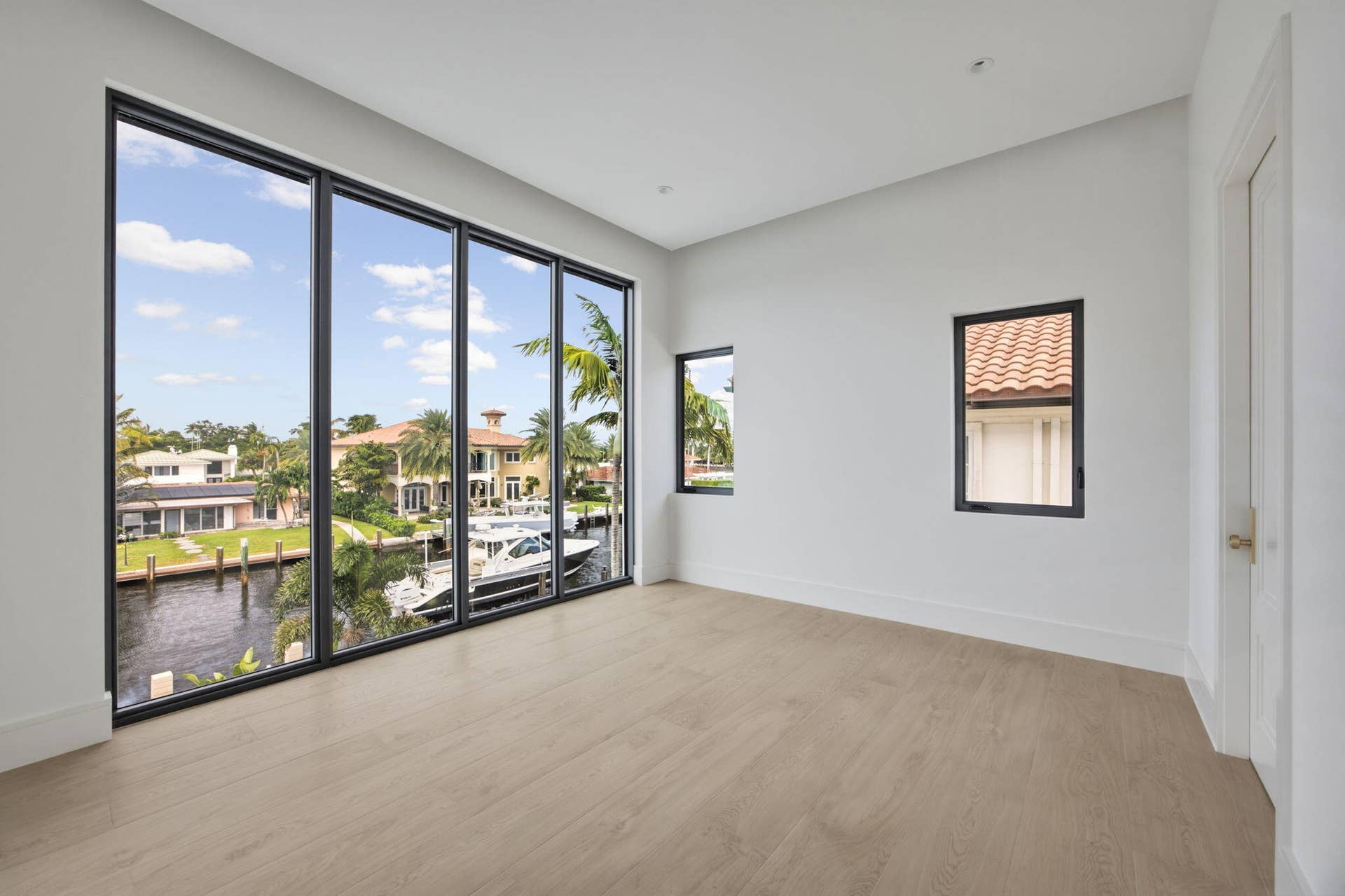 2921 NE 23RD Street, Pompano Beach, FL 33062 Upstairs rear bedroom with canal views, balcony access and onsuite bathroom with 2 vanities, shower and smart toilet