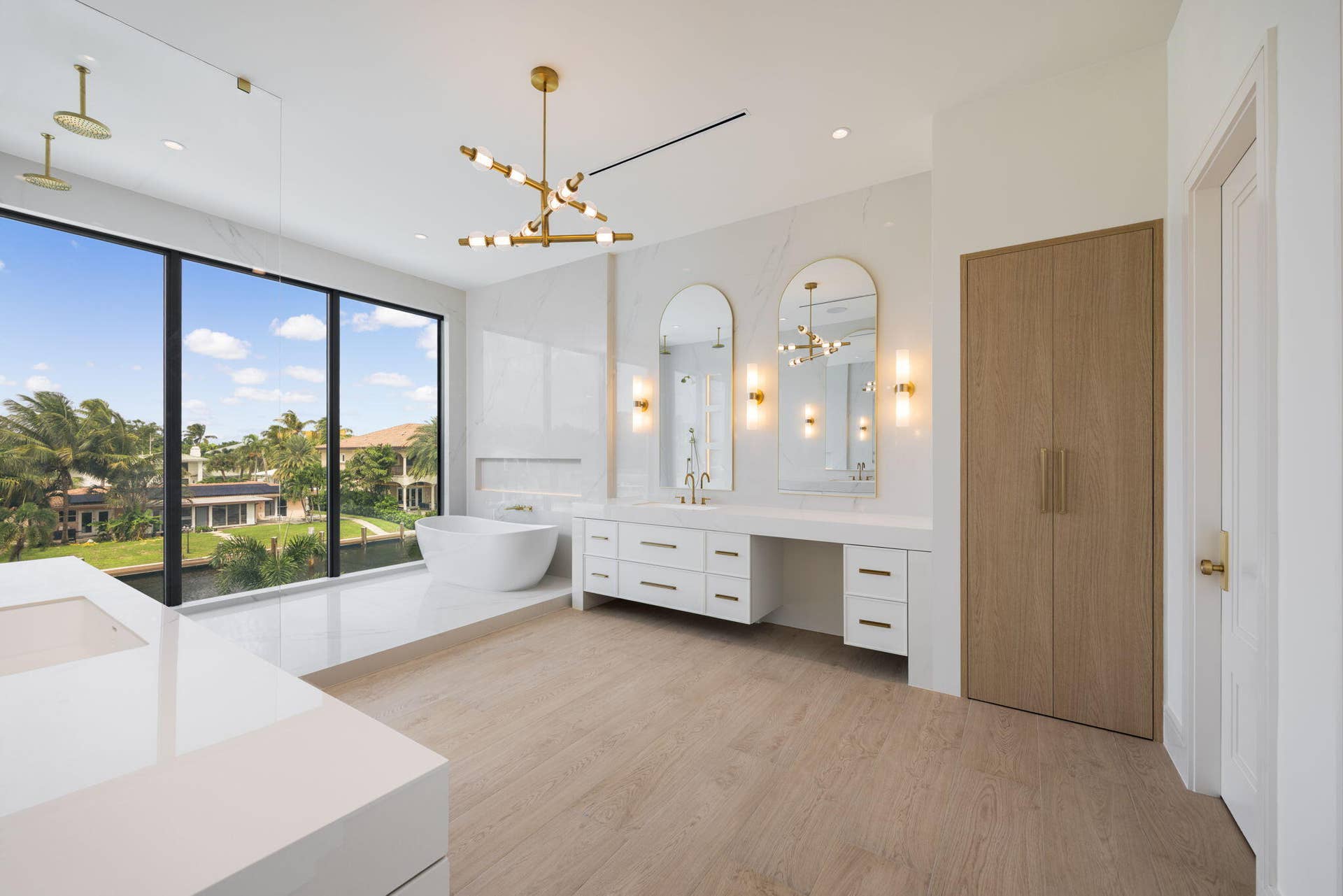 2921 NE 23RD Street, Pompano Beach, FL 33062 Primary Bath custom waterfalls custom shaker shape and color paint cabinets and beauty area and built out custom linen closet and 2 water closets